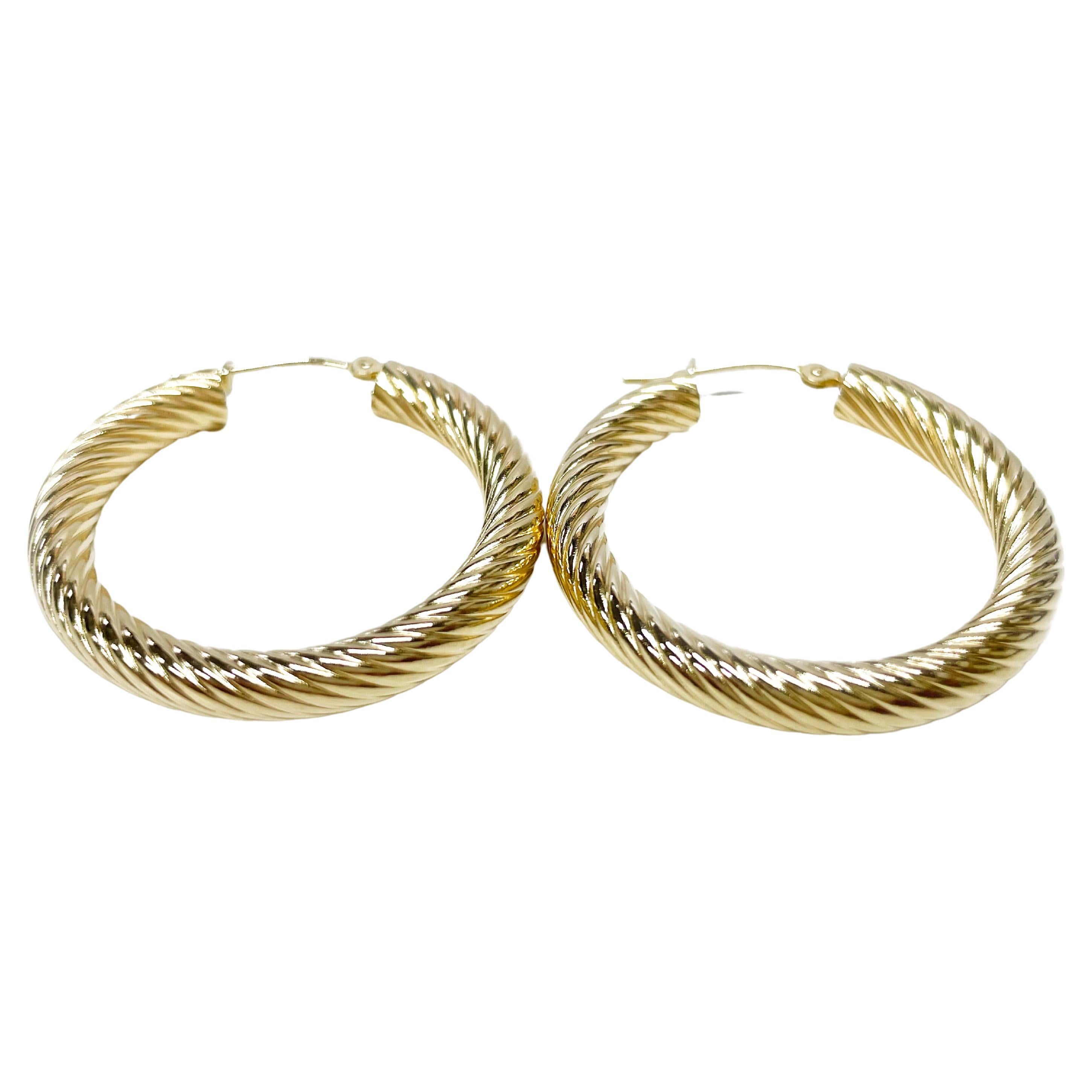 14 Karat Yellow Gold Cable Hoop Earrings. These classic lightweight hoops have just the right amount of detail in their cable design. The earrings have a joint and catch closure. Each earrings measures 30.7 x 30.7mm. The total gold weight of the