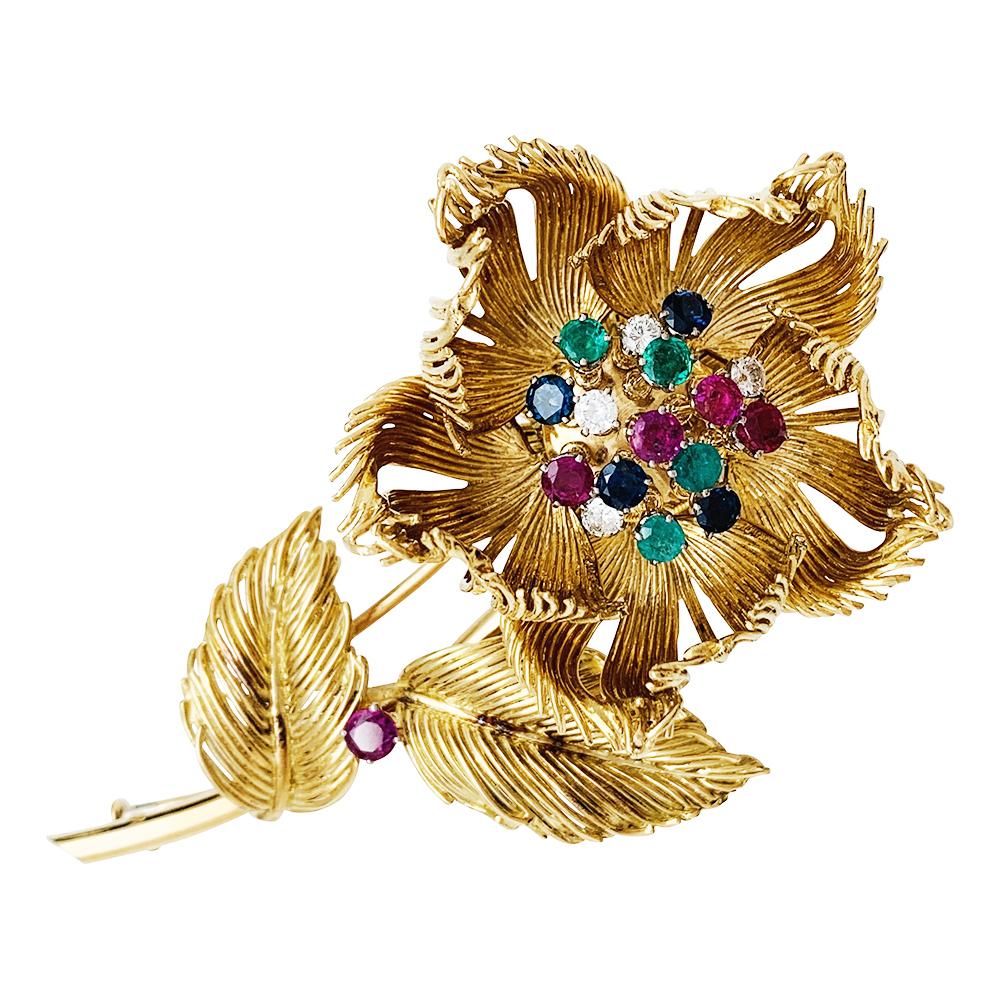 A Cartier flower brooch, made with 750/000 yellow gold threads. The petal can be opened and the trembeling pistils are set with diamonds, emerald, rubies and sapphires. The stem is enhanced with a ruby. 
Diamonds weight: about 0.80 carat
Rubis