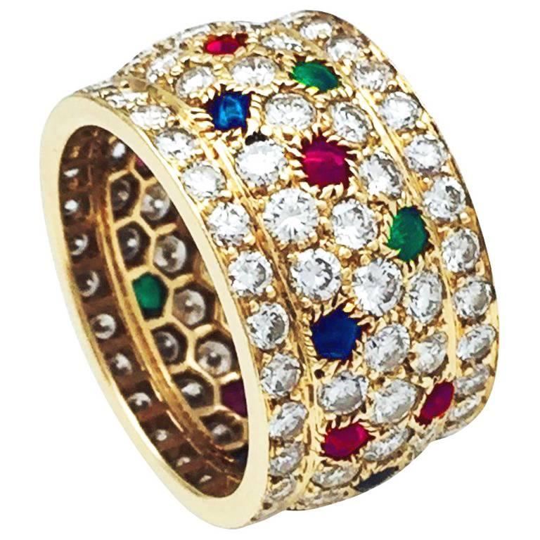 A 750/000 yellow gold Cartier large ring, Nigeria collection, paved with brilliant cut diamonds and enhanced with cabochons emeralds, rubies and sapphires spots.
Width : 13 mm
Weight : 9,6 grams
Size : 7.5
Circa 1989
