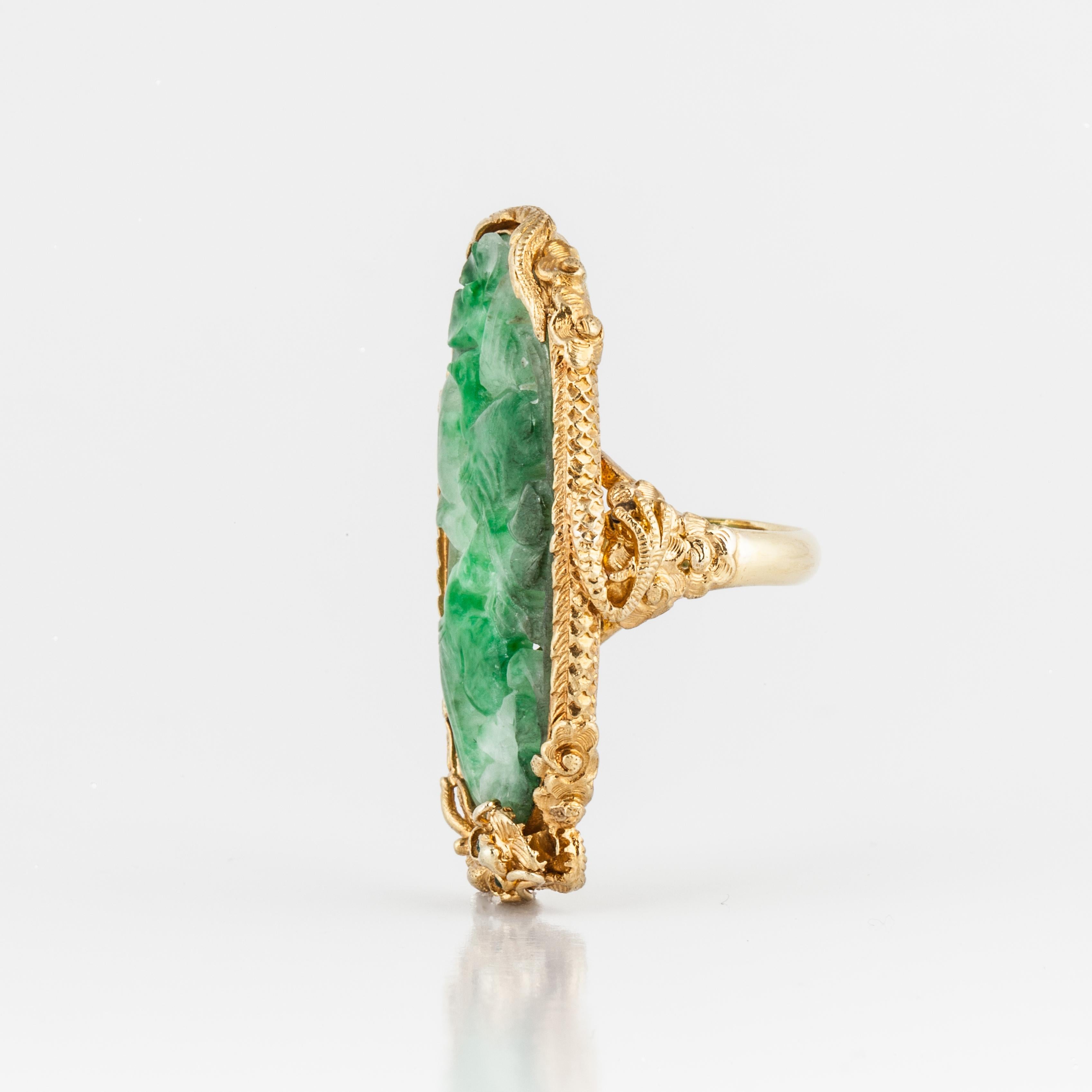 22K yellow gold ring with carved jadeite that has a bird motif.  Surrounding the Jadeite, is a gold dragon with green eyes.  Ring is currently a size 5 1/4.  Presentation area measures 3/4 of an inch wide by 1 1/2 inches in length.
