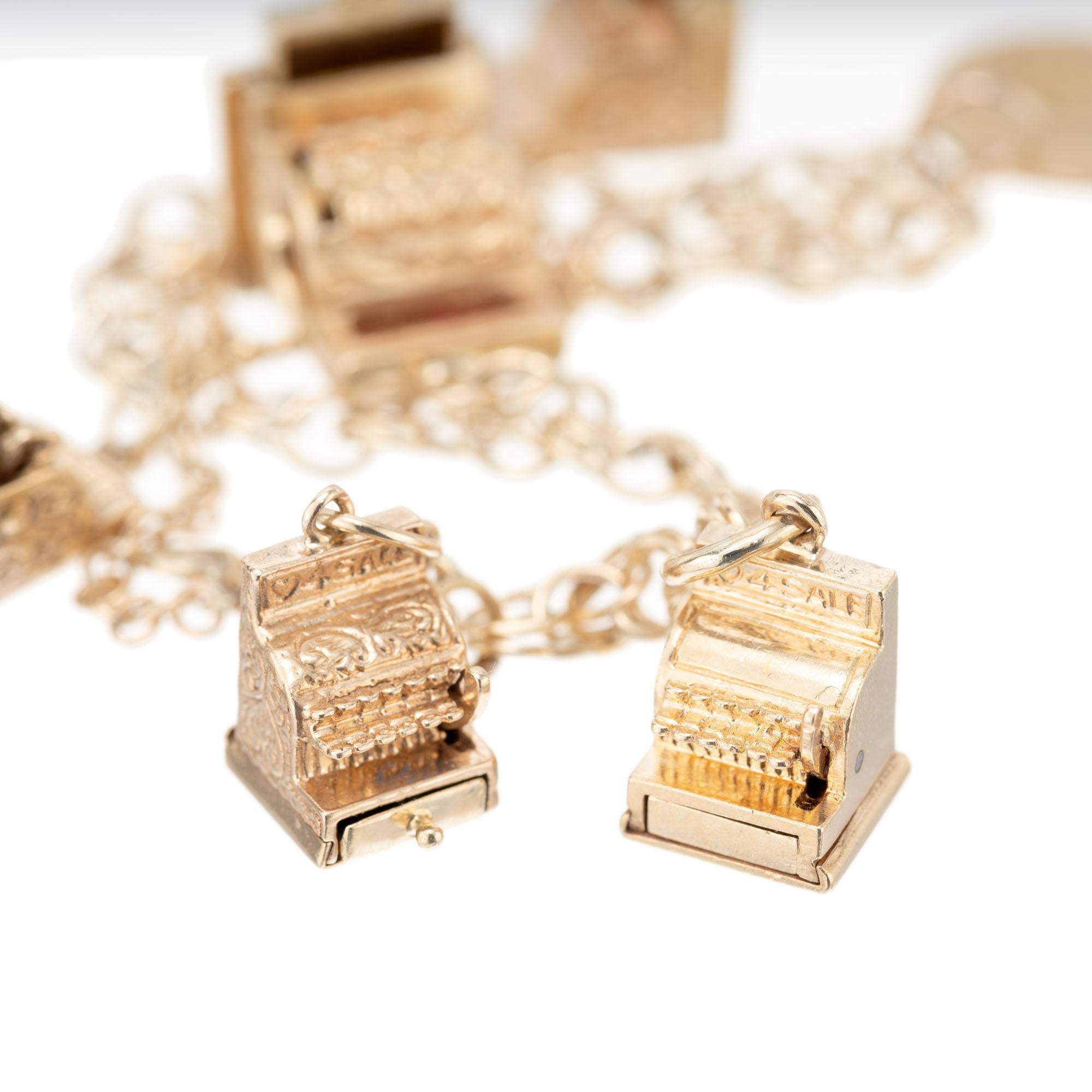 Cash register charm bracelet with five cash registers in solid 14k gold and a US gold coin on a double spiral link bracelet. 7 inches. 

5 cash register charms 
1 US coin
14k yellow gold 
Stamped: 14k
33.0 grams
Bracelet: 7 Inches
Width: 5.5mm
