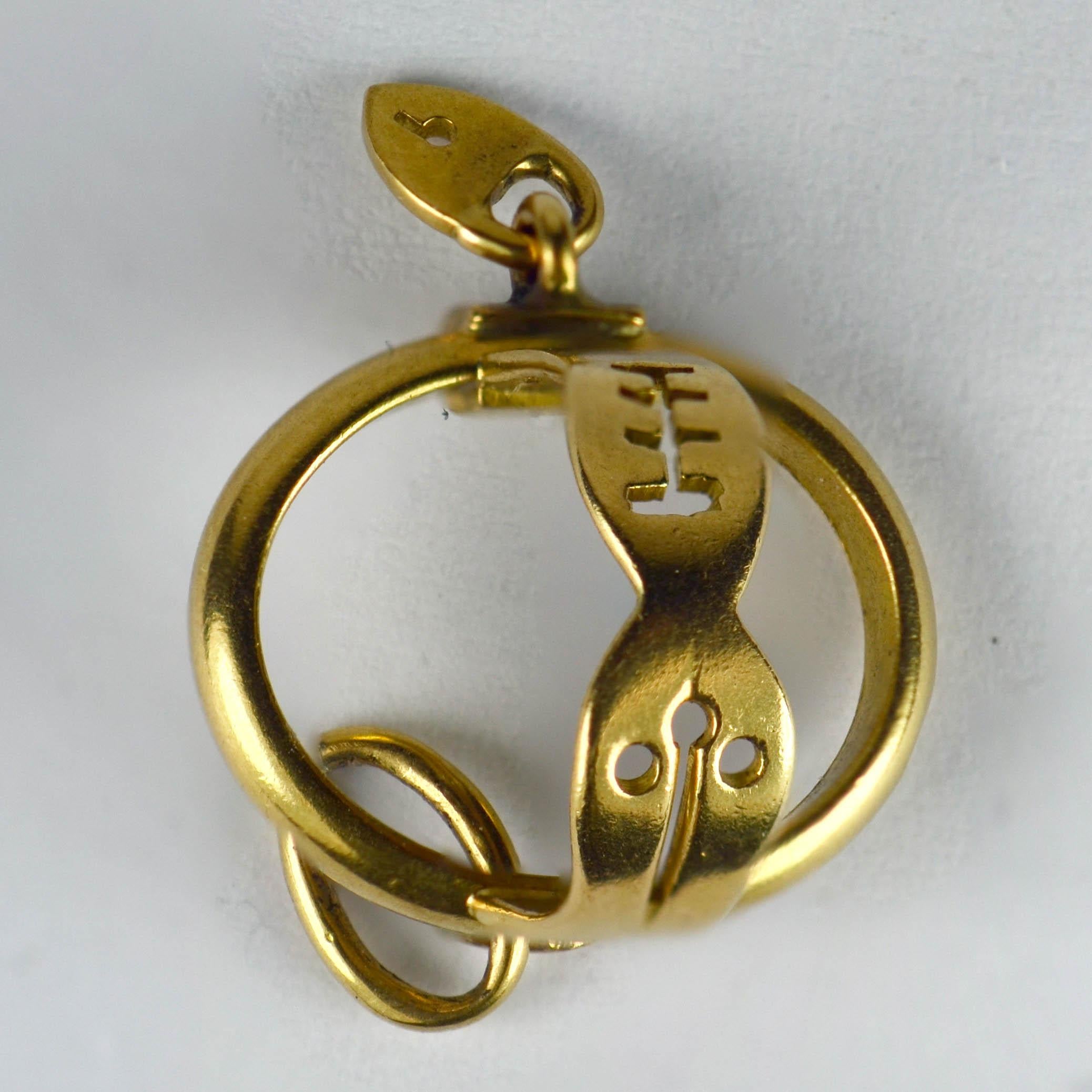 An unusual and amusing charm pendant in 18 karat yellow gold designed as a chastity belt with a love heart padlock. Stamped with the French import mark for 18 karat gold.

Dimensions: 1.5 x 1.3 x 1.2 cm
Weight: 1.37 grams