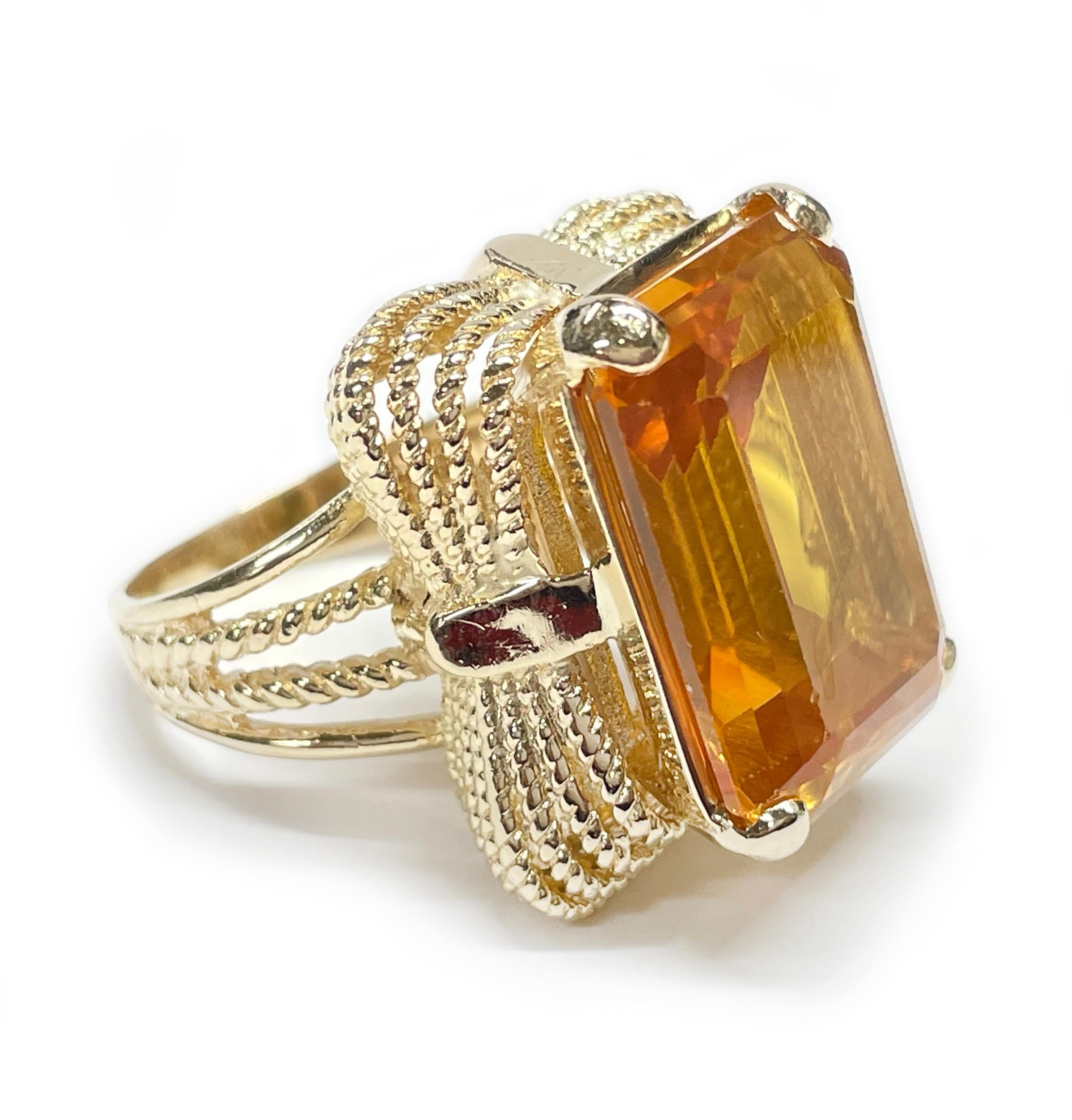 14 Karat Yellow Gold Citrine Cocktail Ring. The ring features an emerald cut 20 x 15mm prong-set golden Citrine. There are twisted wire scroll-like designs adorning all sides of the Citrine and the split band. The Citrine stone has light wear