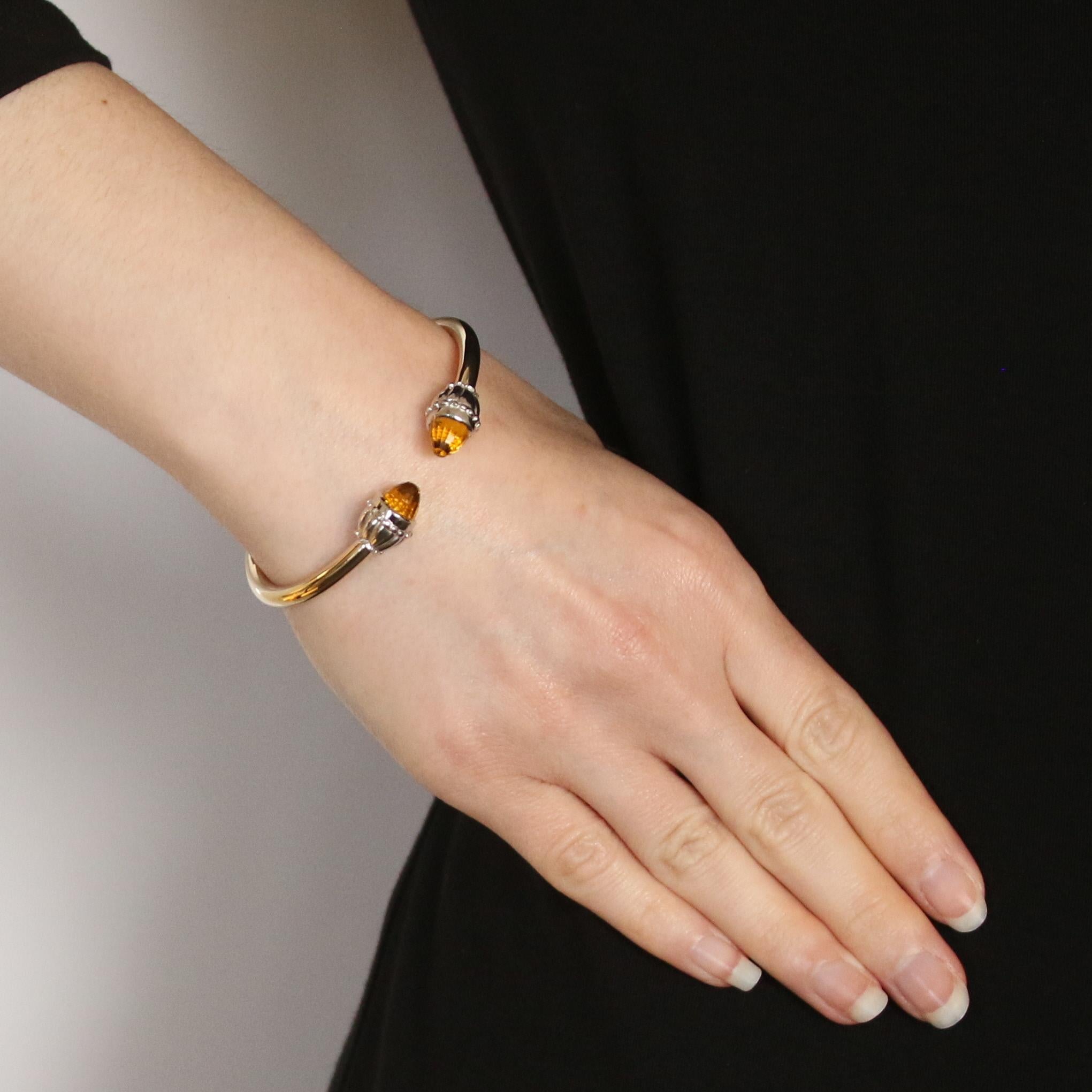 Metal Content: 14k Yellow Gold & 14k White Gold
 
 Stone Information: 
 Genuine Citrines
 Treatment: Heating
 Cut: Briolette
 Color: Yellow
 
 Bracelet Style: Hinged Negative Space Bangle
 Closure Type: N/A (slides over wrist)
 
 Measurements: 
