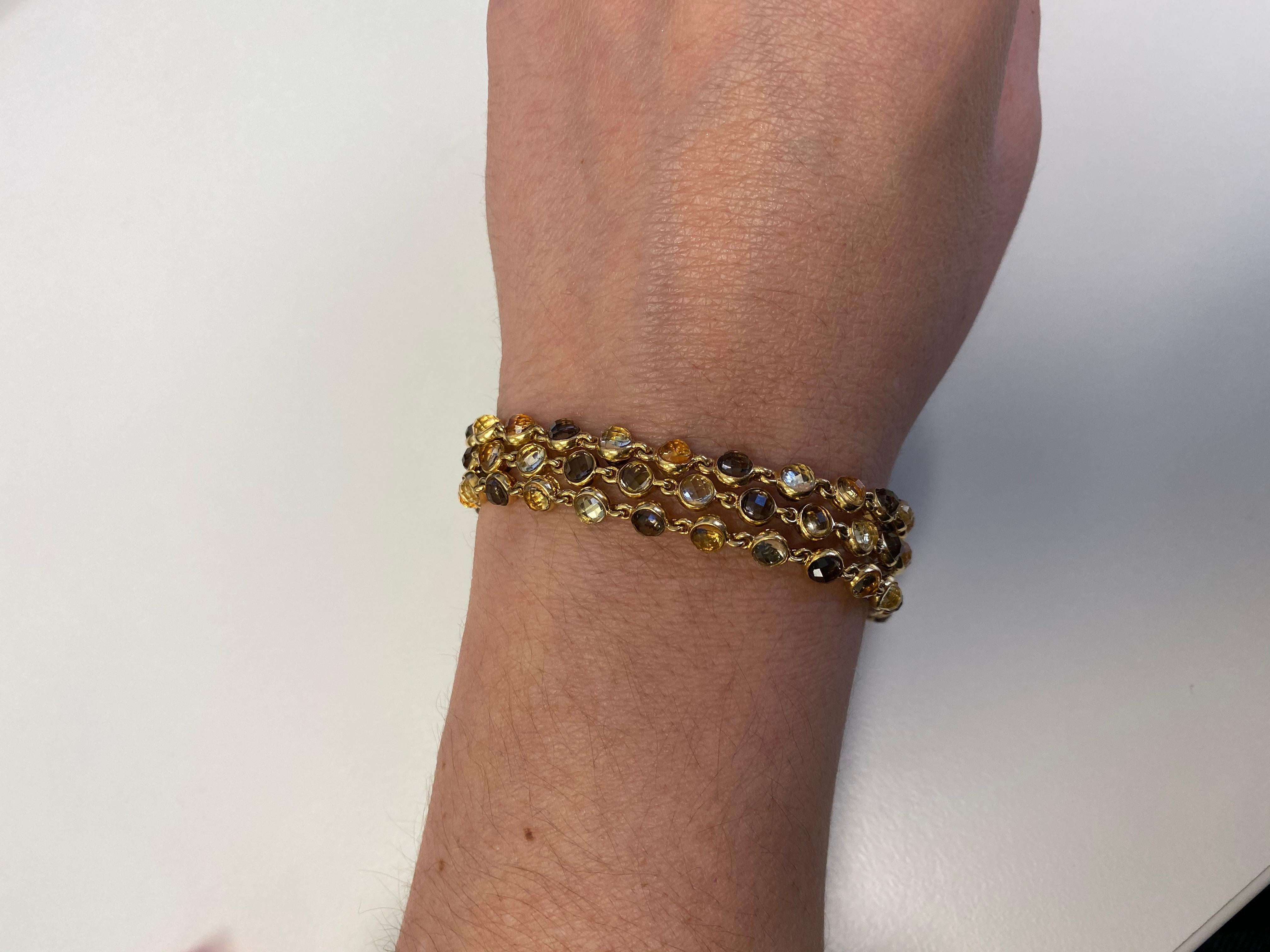 Hammerman Brothers 18 karat yellow gold bracelet with three strands of citrine, smokey topaz, and lemon quartz. The stones are cleverly set with varying colors from front to back, scintillating different flashes of color as you move your wrist. 