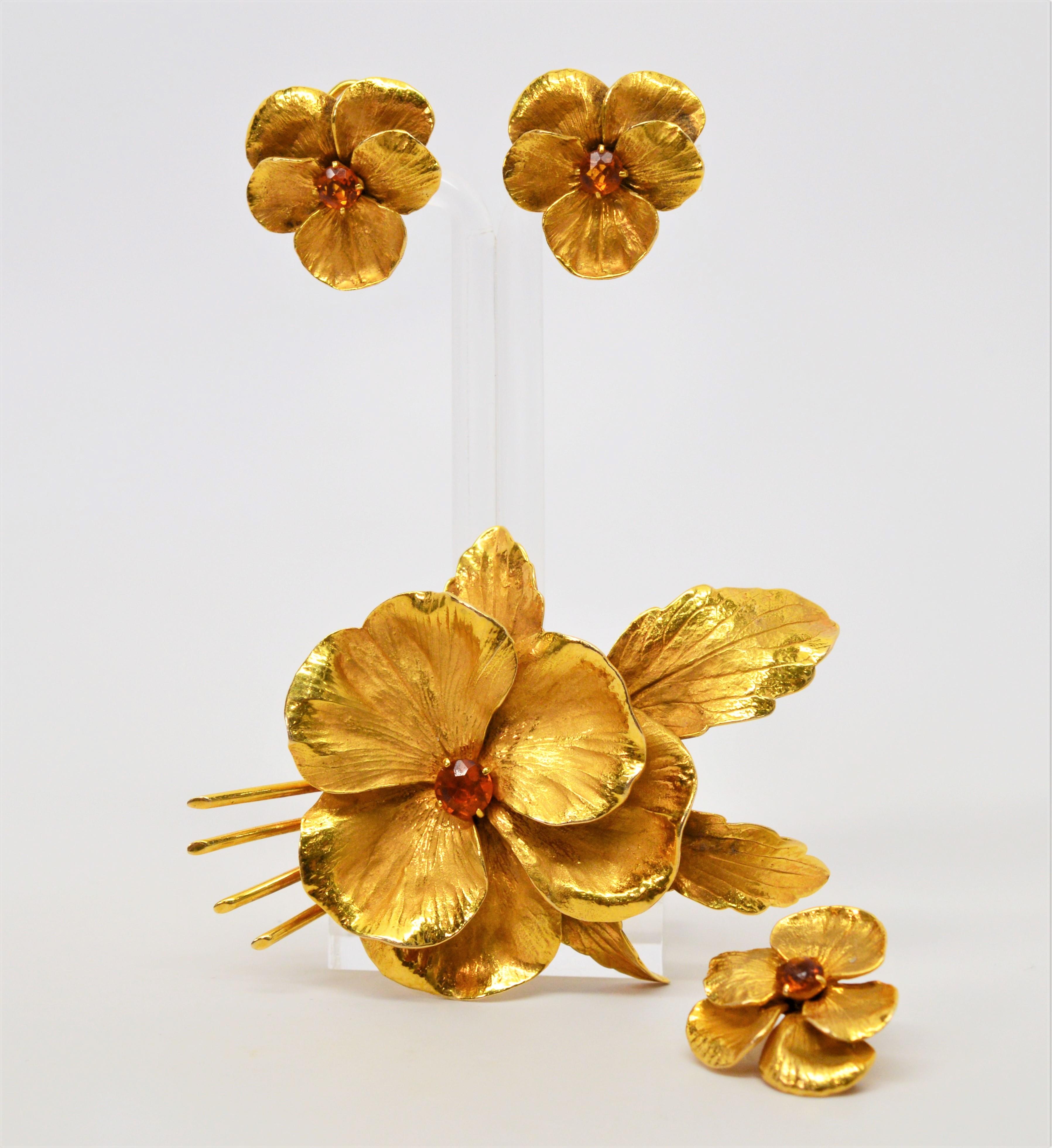 Each bloom displays spectacular detail in this floral suite of matching earrings and two brooch pins made of fourteen karat 14K yellow gold. 
Bright citrine centers adorned each floral bud. The feature brooch has pansy-like blossoms and is coupled