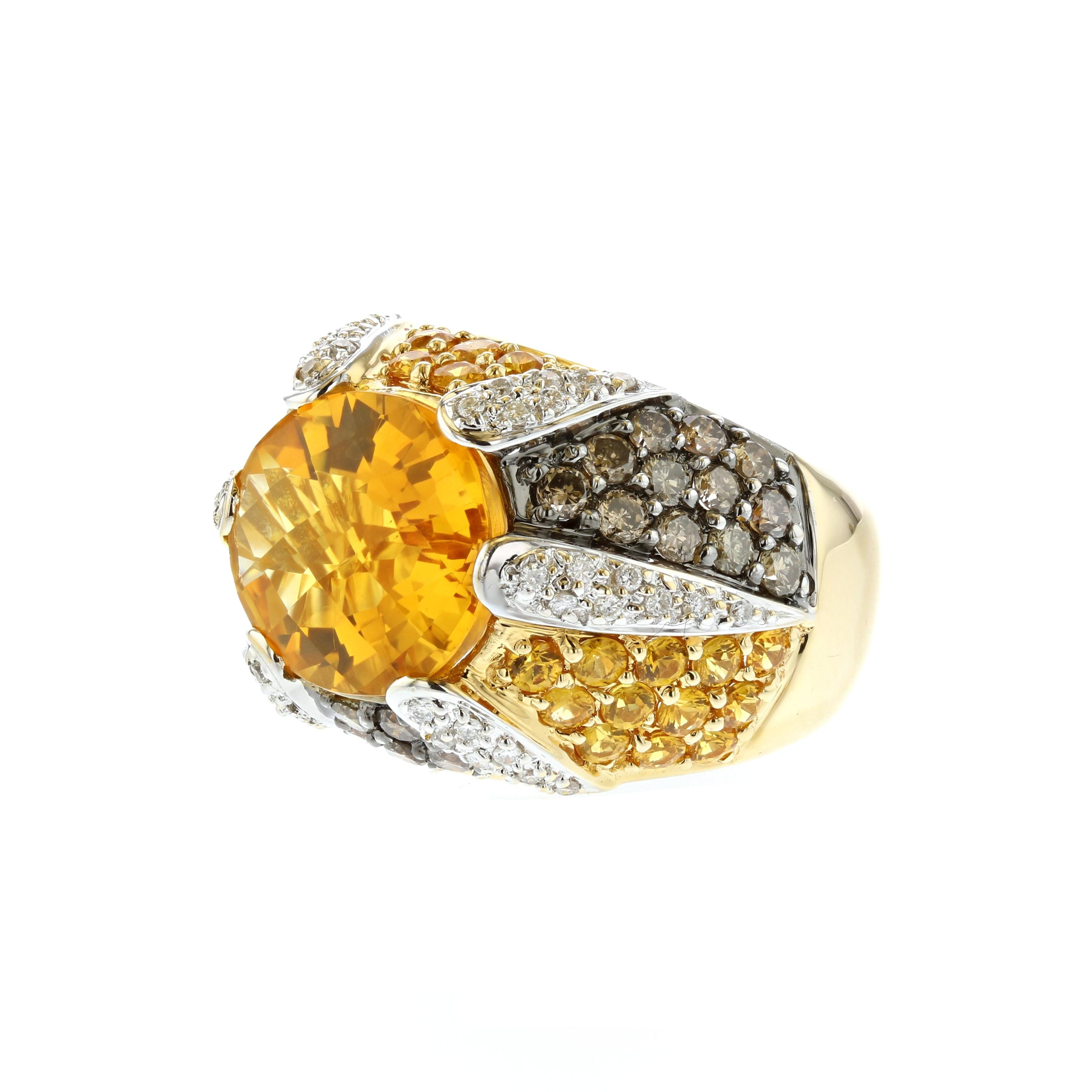 18K yellow gold ring featuring one oval citrine that totals 6.70 carats.  In addition, there are twenty-nine round yellow sapphires that total 1.75 carats, twenty-nine (29) round brown diamonds that total 1.45 carats and forty-four round brilliant