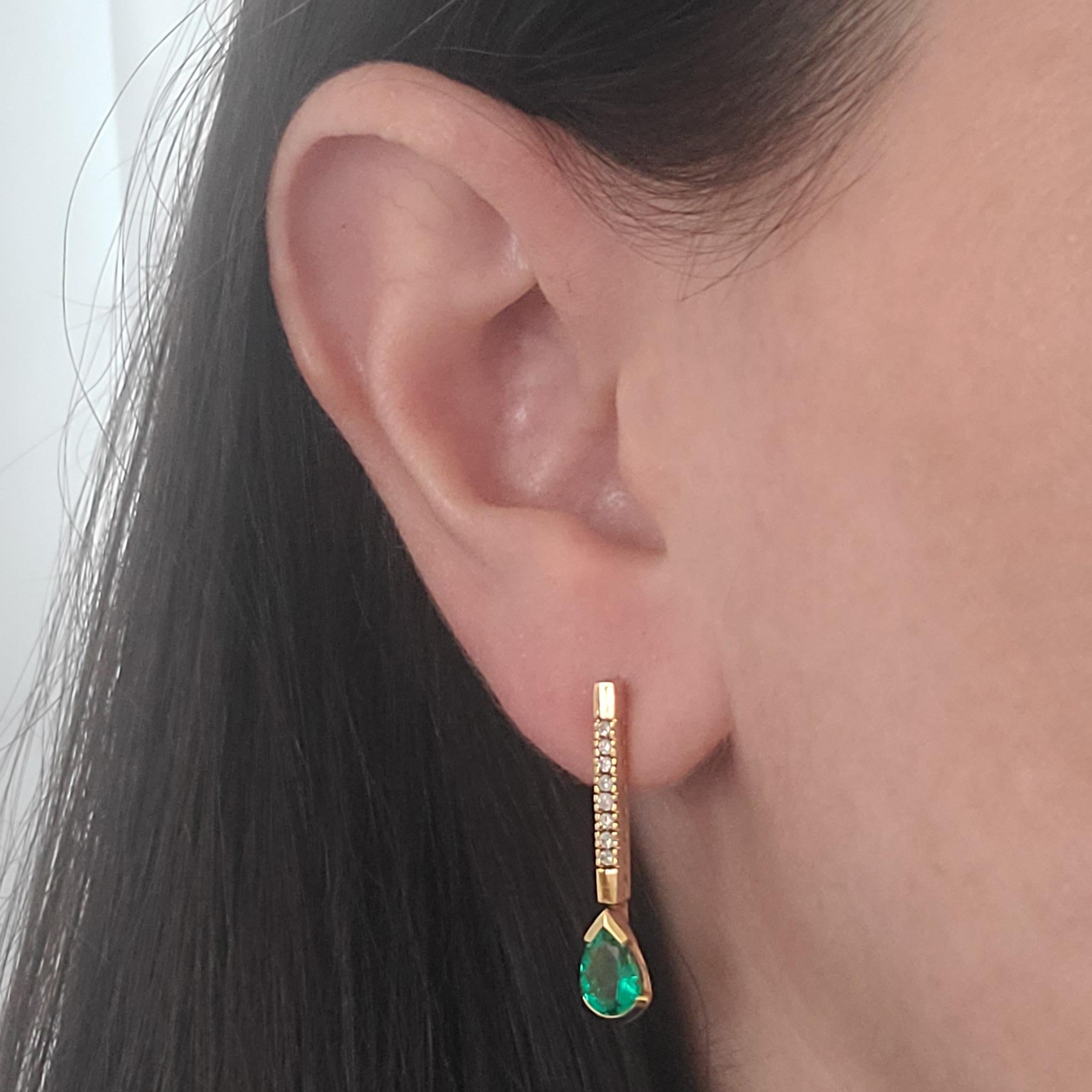 14 Karat Yellow Gold Drop Earrings Featuring 2 Pear Cut Colombian Emeralds Totaling Approximately 1.10 Carats Accented By 16 Round Diamonds Totaling An Additional 0.16 Carats. GIA Report #5222342191. Pierced Post With Friction Back. 1.12 Inch