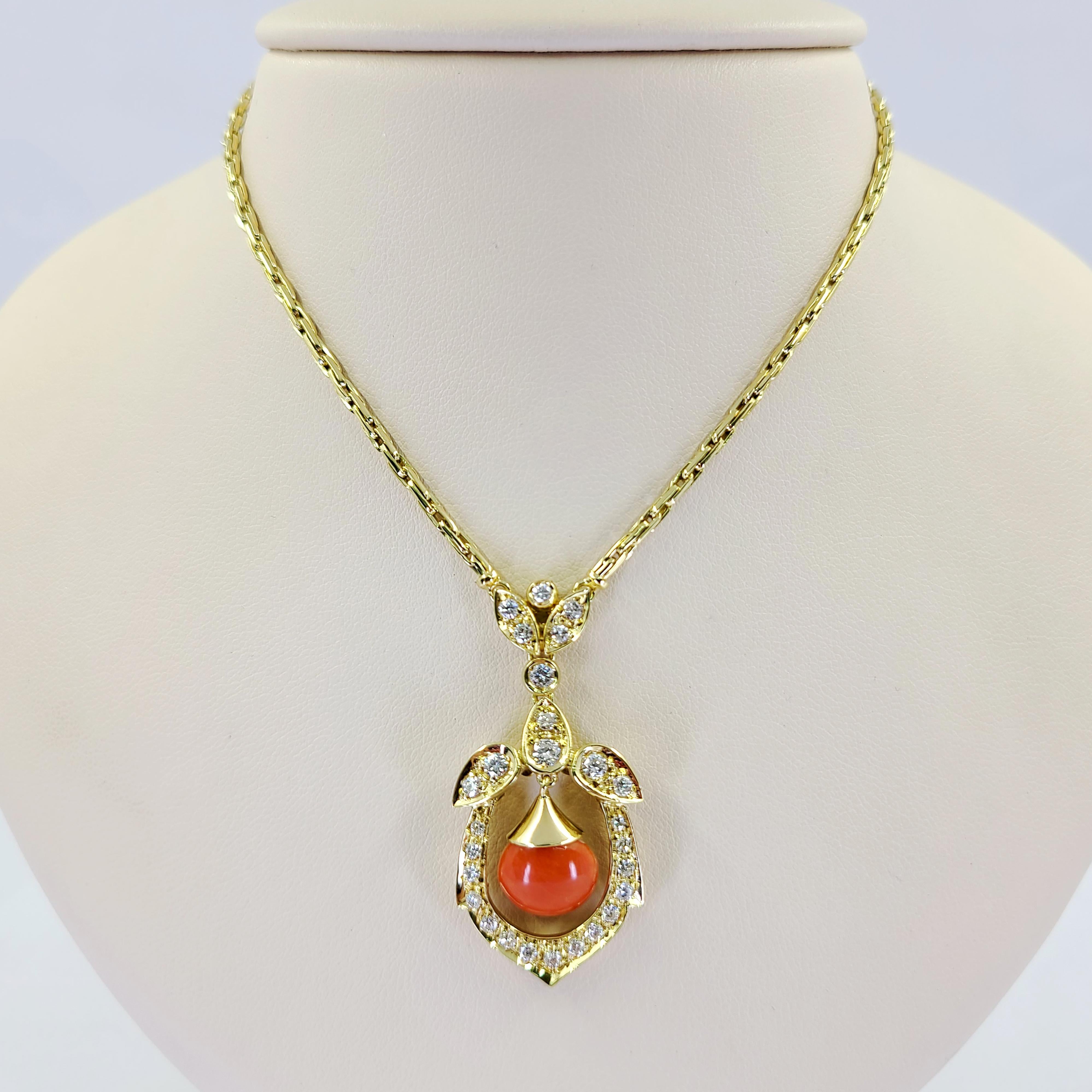 18 Karat Yellow Gold Necklace Featuring A Cabochon Coral Pendant Accented By 27 Round Brilliant Cut Diamonds of VS Clarity and G/H Color Totaling Approximately 0.75 Carats. 18 Inch Length with 1.75 Inch Drop. Finished Weight Is 21.4 Grams.