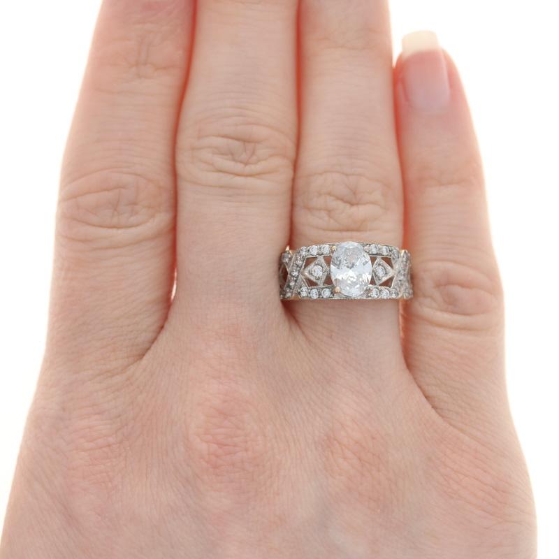 Size: 6 3/4
Sizing Fee: Up 2 sizes and down 1 sizes for $50

Metal Content: 14k Yellow Gold & 14k White Gold

Stone Information
Cubic Zirconia Solitaire
Carat: 1.40ct dew
Cut: Oval 
Color: Clear

Cubic Zirconia Accents 
Carats: 1.10ctw dew
Cut: