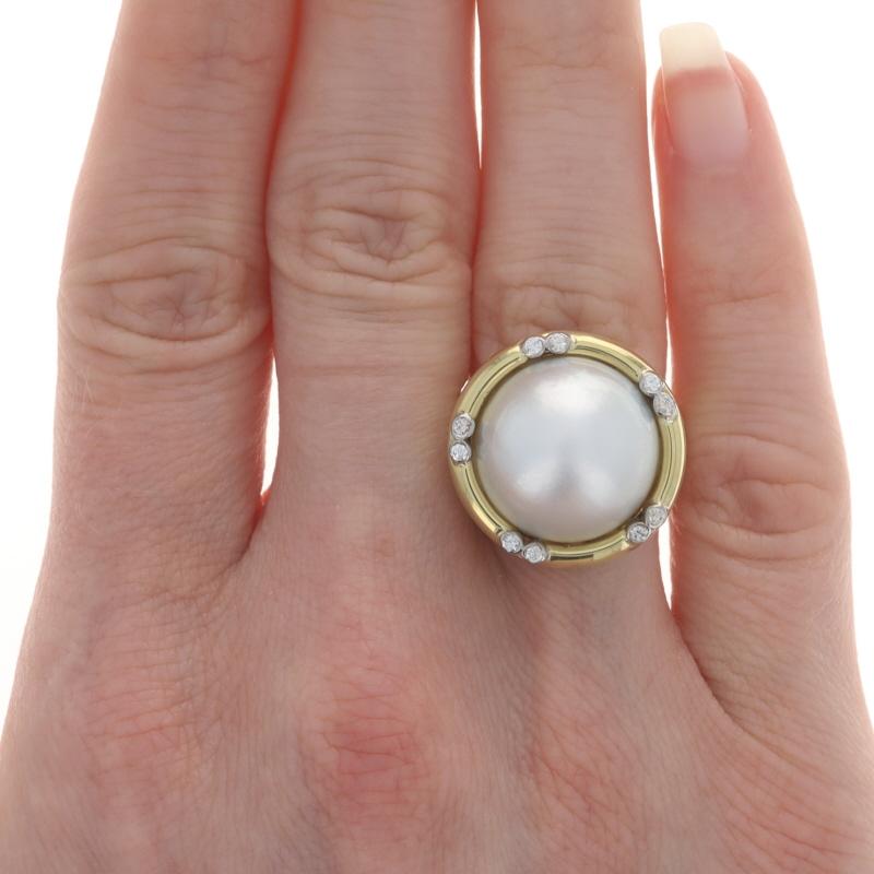 Size: 6 1/4
Sizing Fee: Up 2 sizes for $50 or Down 1 size for $40

Metal Content: 18k Yellow Gold & 18k White Gold

Stone Information
Cultured Mabe Pearl
Color: White
Size: (approx) 15.4mm

Natural Diamonds
Carat(s): .12ctw
Cut: Round