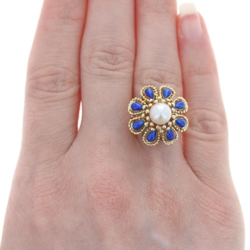 Size: 6 1/4
Sizing Fee: Down 2 sizes for $30 or up 2 sizes for $35

Era: Vintage

Metal Content: 14k Yellow Gold

Stone Information
Genuine Cultured Pearl
Diameter: 7mm

Material Information:
Enamel
Color: Blue

Style: Halo
Theme: Flower