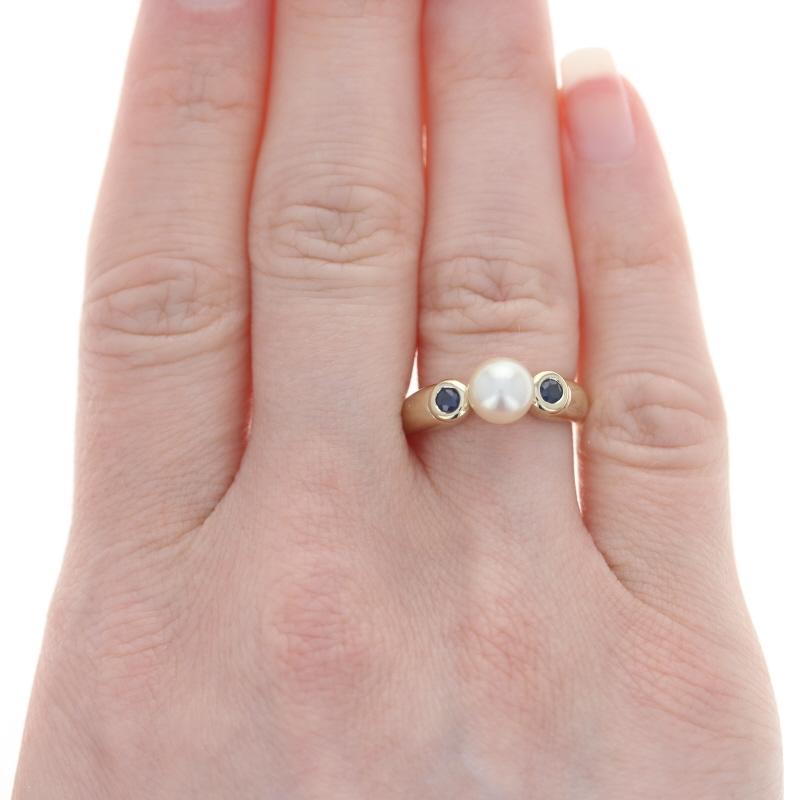 Size: 6
Sizing Fee: Down 2 for $30 or up 2 for $35

Metal Content: 14k Yellow Gold

Stone Information
Cultured Pearl
Size: 6.8mm

Genuine Sapphires
Treatment: Heating
Total Carat(s): .22ctw
Cut: Round 
Color: Blue

Style: Solitaire with