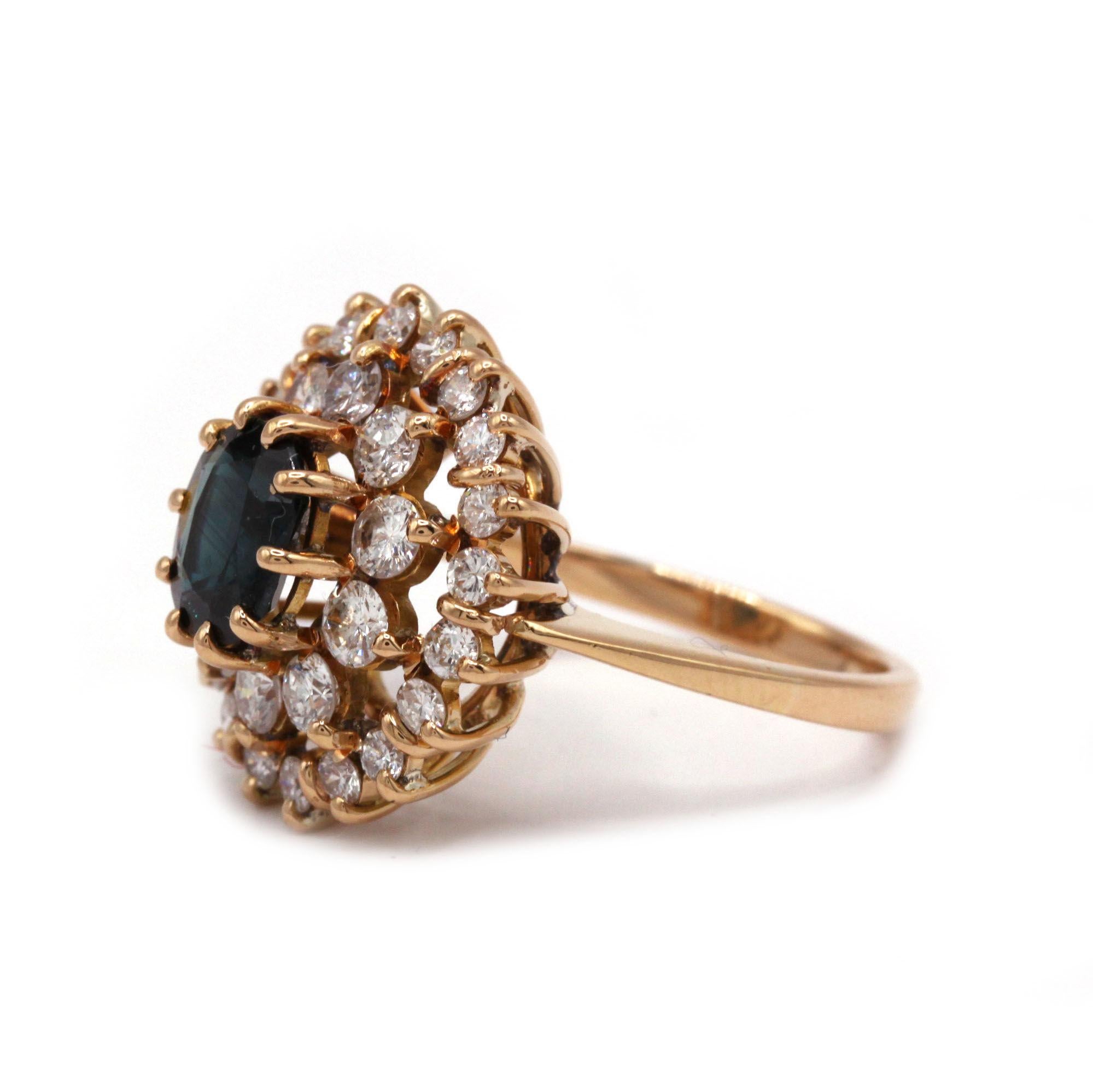 This bold daisy-style ring is crafted in 18K yellow gold and centers on a cushion-cut Ceylon sapphire of approximately 1.40 carats. The sapphire is haloed by two tiers of brilliant-cut diamonds—thirty stones weighing a total of about 1.20 carats—set