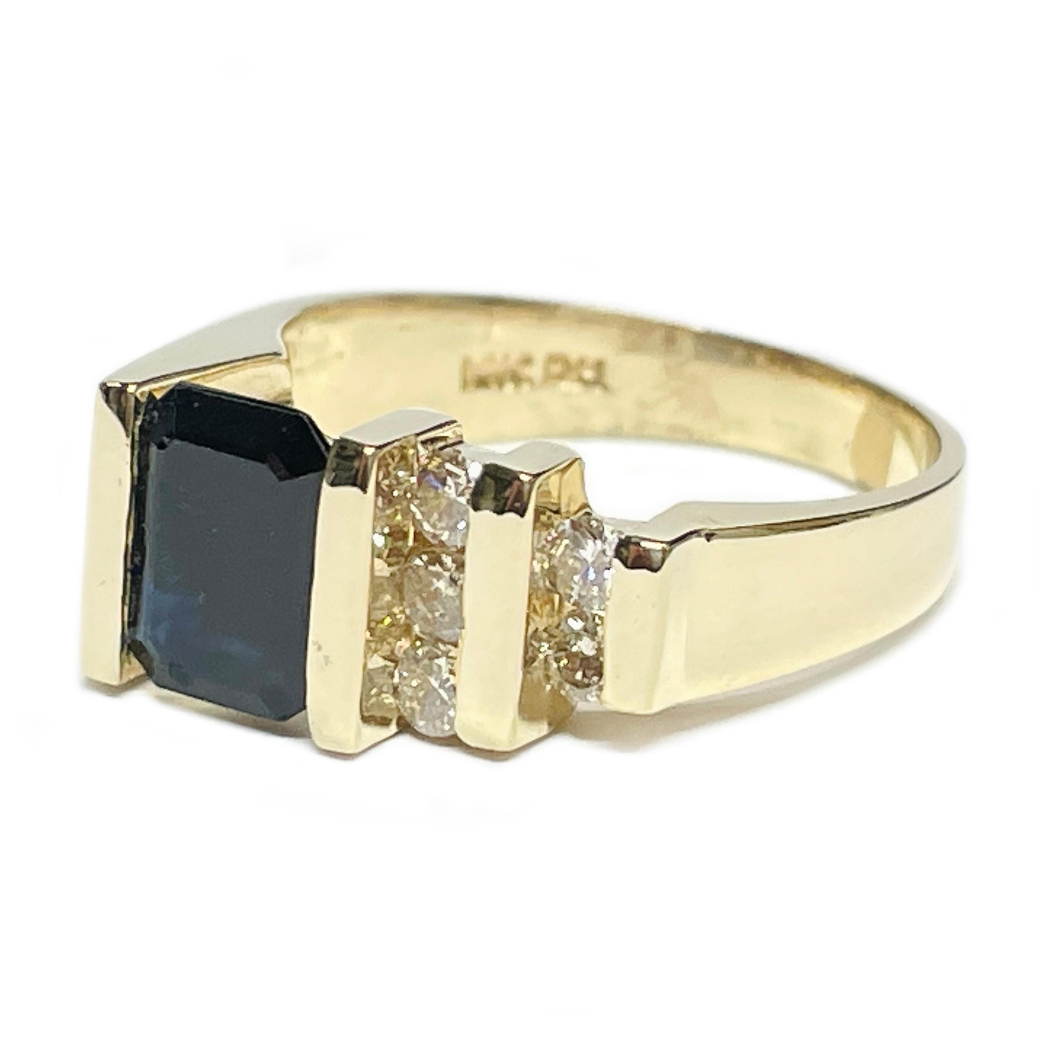 14 Karat Yellow Gold Dark Blue Sapphire Diamond Ring. The ring features a dark blue step-cut sapphire and channel-set diamonds on one side. The sapphire measures 8 x 6mm and is dark blue in color with a carat weight of 1.90ct. There are five round