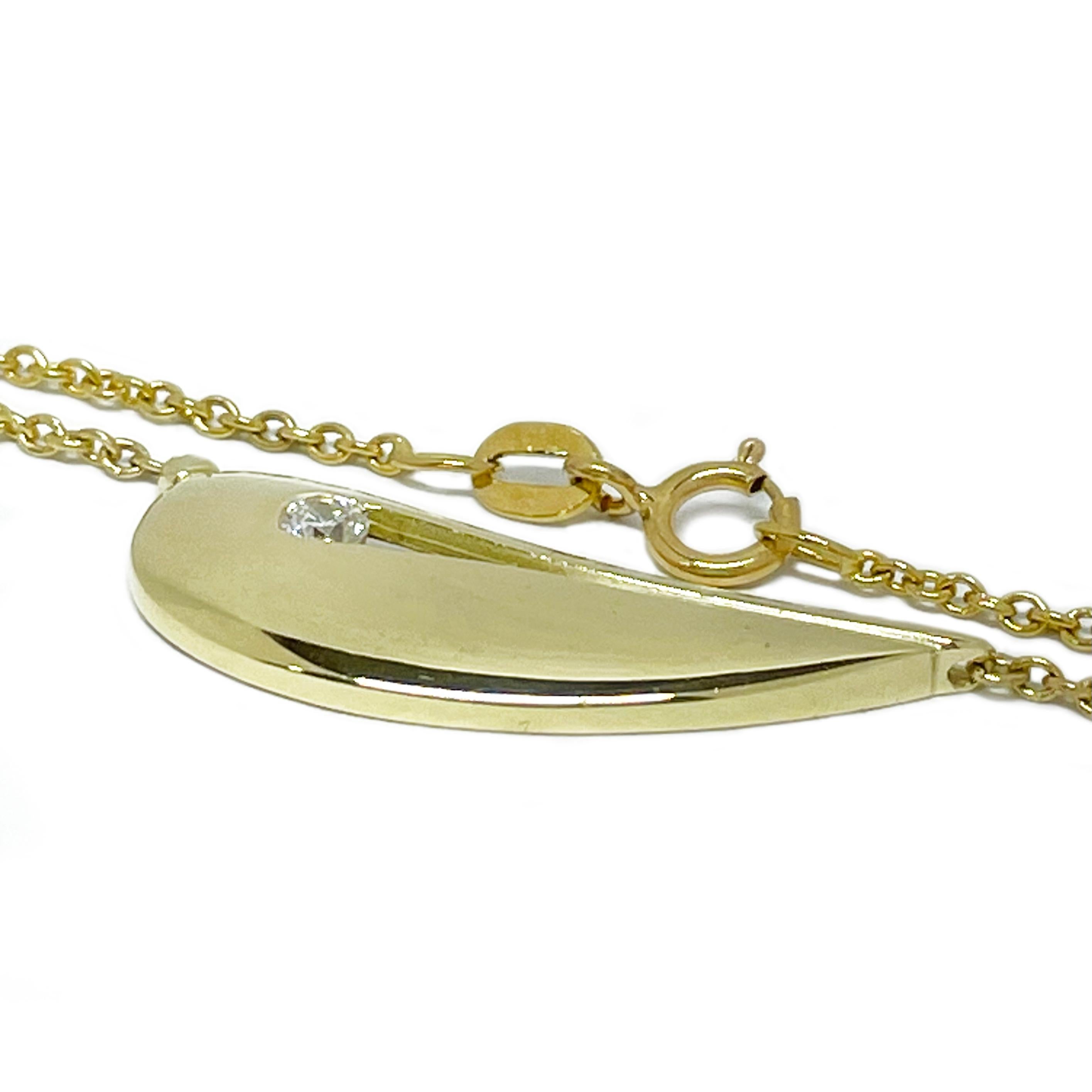 This Yellow Gold Organic Shape Diamond Necklace showcases a beautifully sculpted pendant with a smooth, polished finish. Designed with an open-slot detail, it elegantly holds a 3mm invisibly set diamond, adding a subtle yet radiant sparkle. The