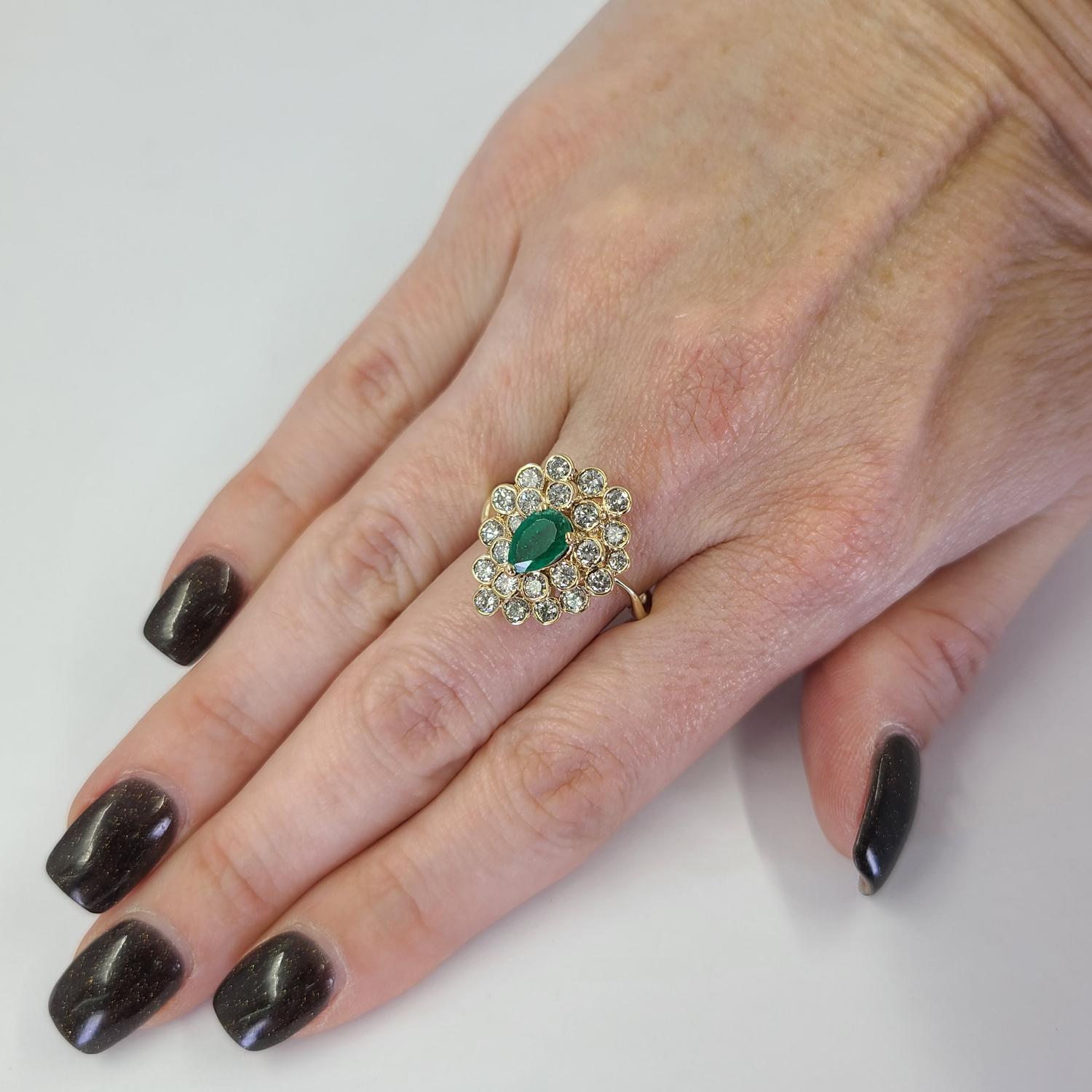 14 Karat Yellow Gold Cluster Ring Featuring A 0.50 Carat Pear Cut Emerald Accented By 23 Round Brilliant Cut Diamonds Of SI Clarity & J Color Totaling Approximately 1 Carat. Finger Size 8.5; Purchase Includes One Sizing Service. Finished Weight Is