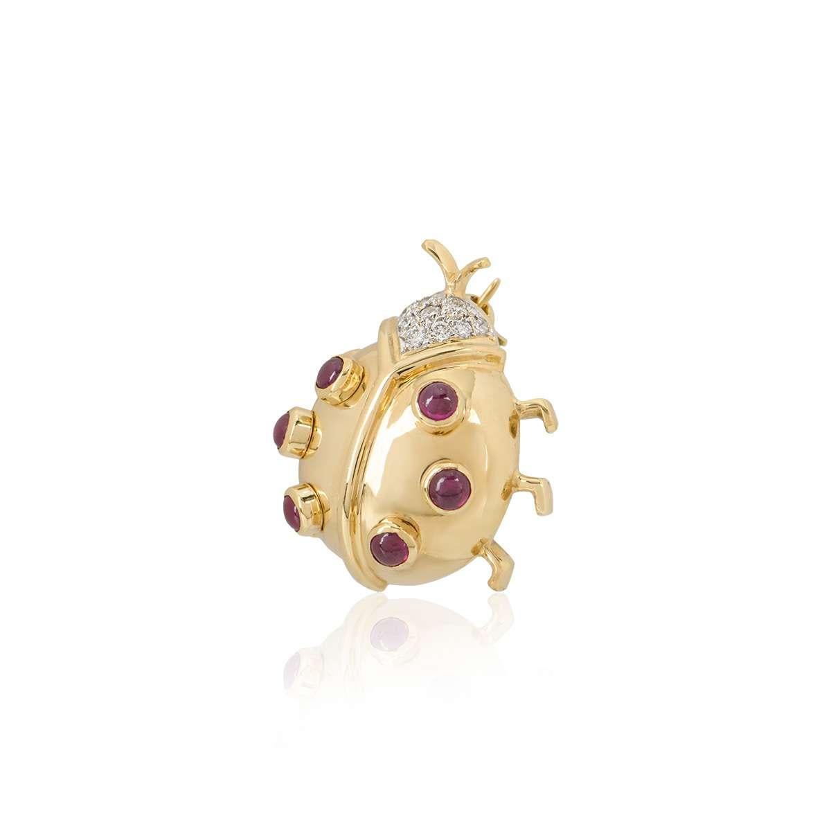 An 18k yellow gold Ladybird brooch. The brooch is set with 6 cabochon rubies throughout the body and 10 round brilliant cut diamonds set in the head. The rubies total approximately 0.30ct and the diamonds total approximately 0.12ct. The butterfly