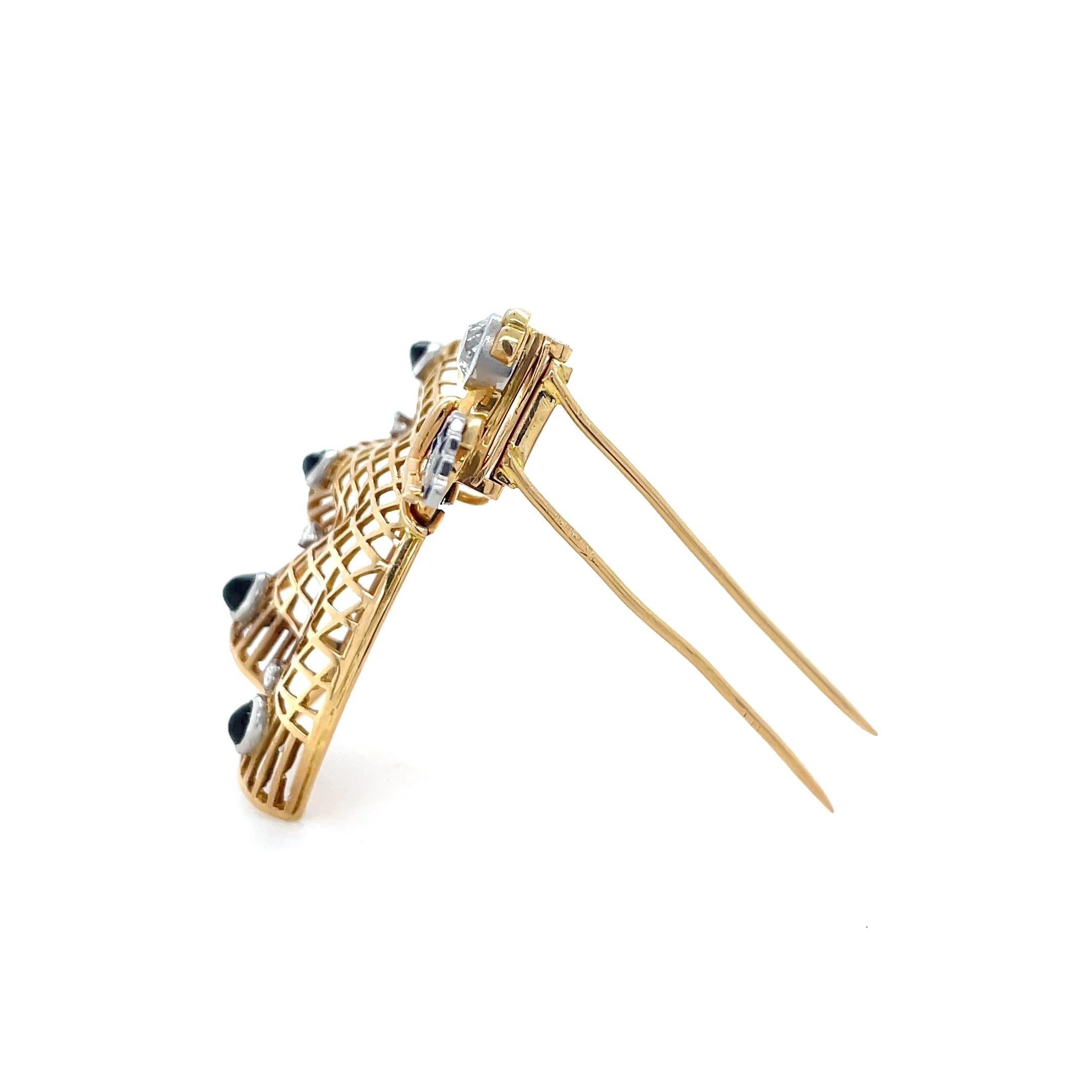 This whimsical ballerina brooch contains an old mine cut diamond face with oval cabochon sapphire and diamond skirt and holding a French cut embellished fan.

Metal: 18 karat yellow gold.
Measurements: 1 3/4 x 1 3/4 inches
Gross weight: 16.90 grams