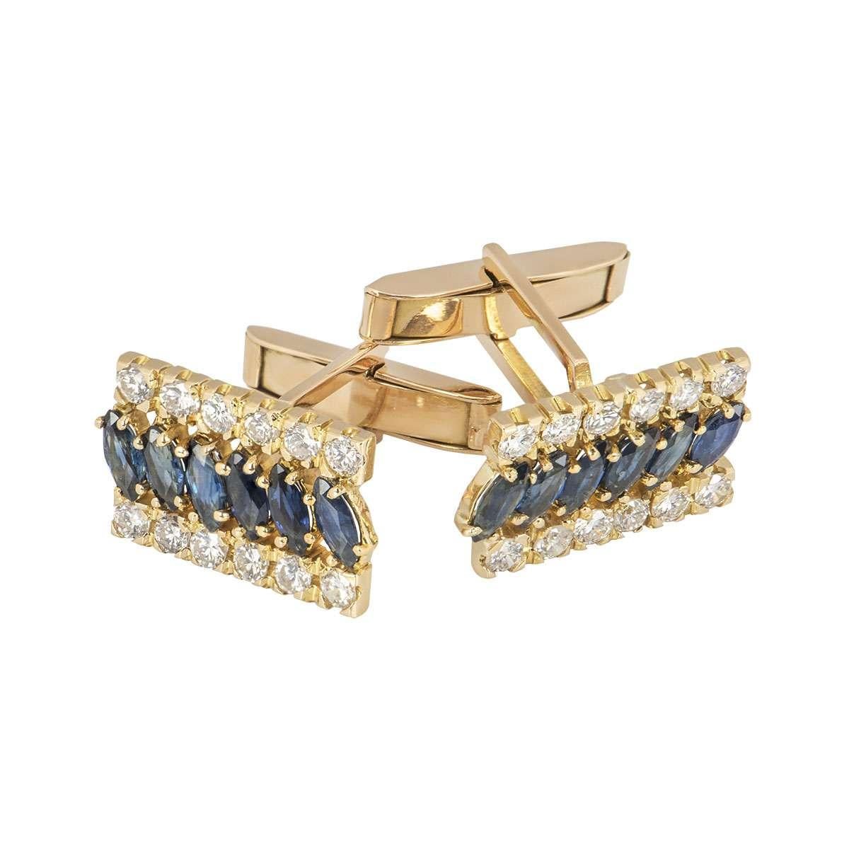 A pair of 18k yellow gold diamond and sapphire cufflinks. The cufflinks are set with a row of round brilliant cut diamonds on top and bottom with a row of marquise shaped sapphires set in between. The 24 diamonds have an approximate gross weight of