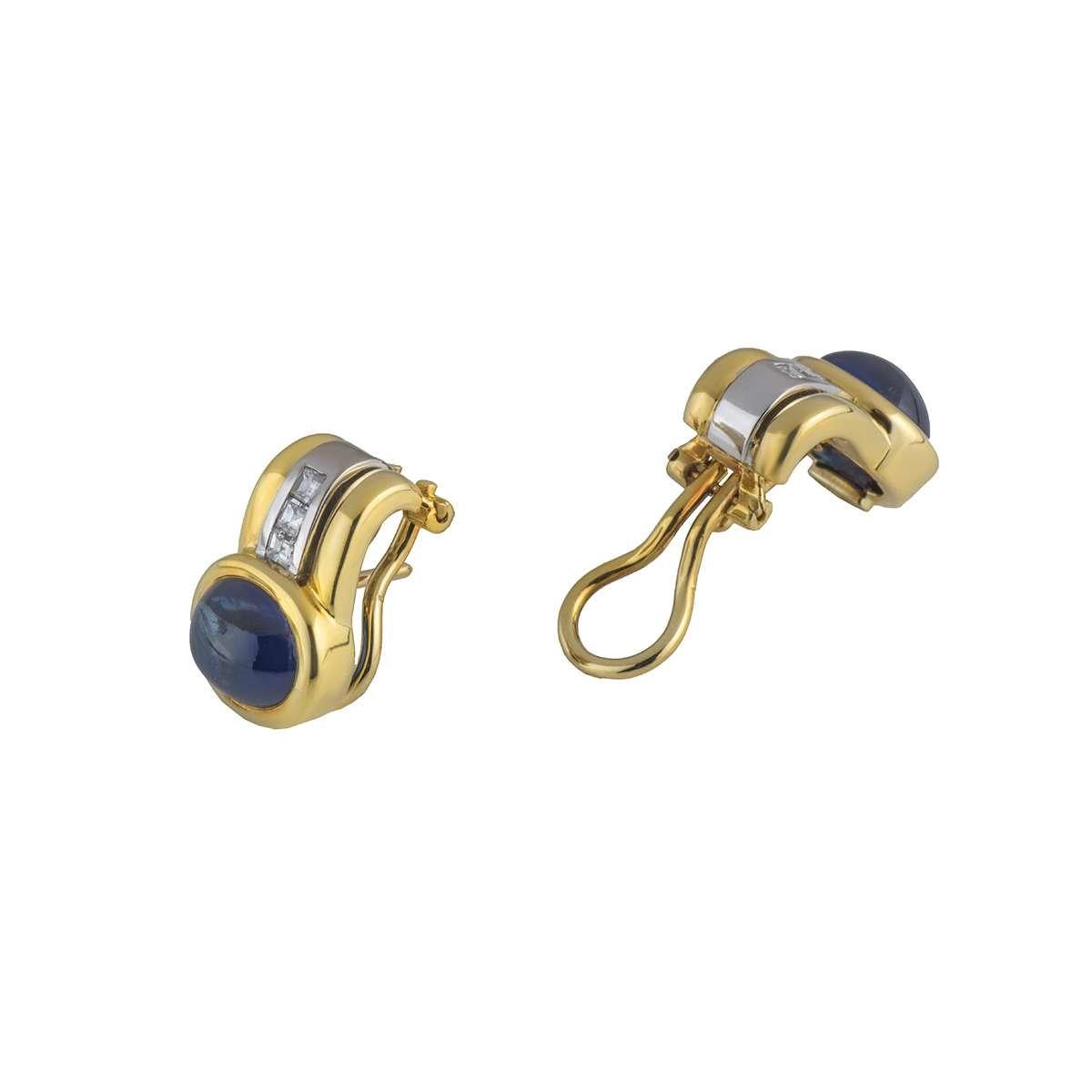 Un par único de pendientes de oro amarillo de 18 quilates, diamantes y zafiros. Los pendientes llevan un zafiro cabujón en un engaste rubover, con un peso total de 5,89 ct. Seguidos de 3 diamantes talla princesa en engaste de canal, con un peso