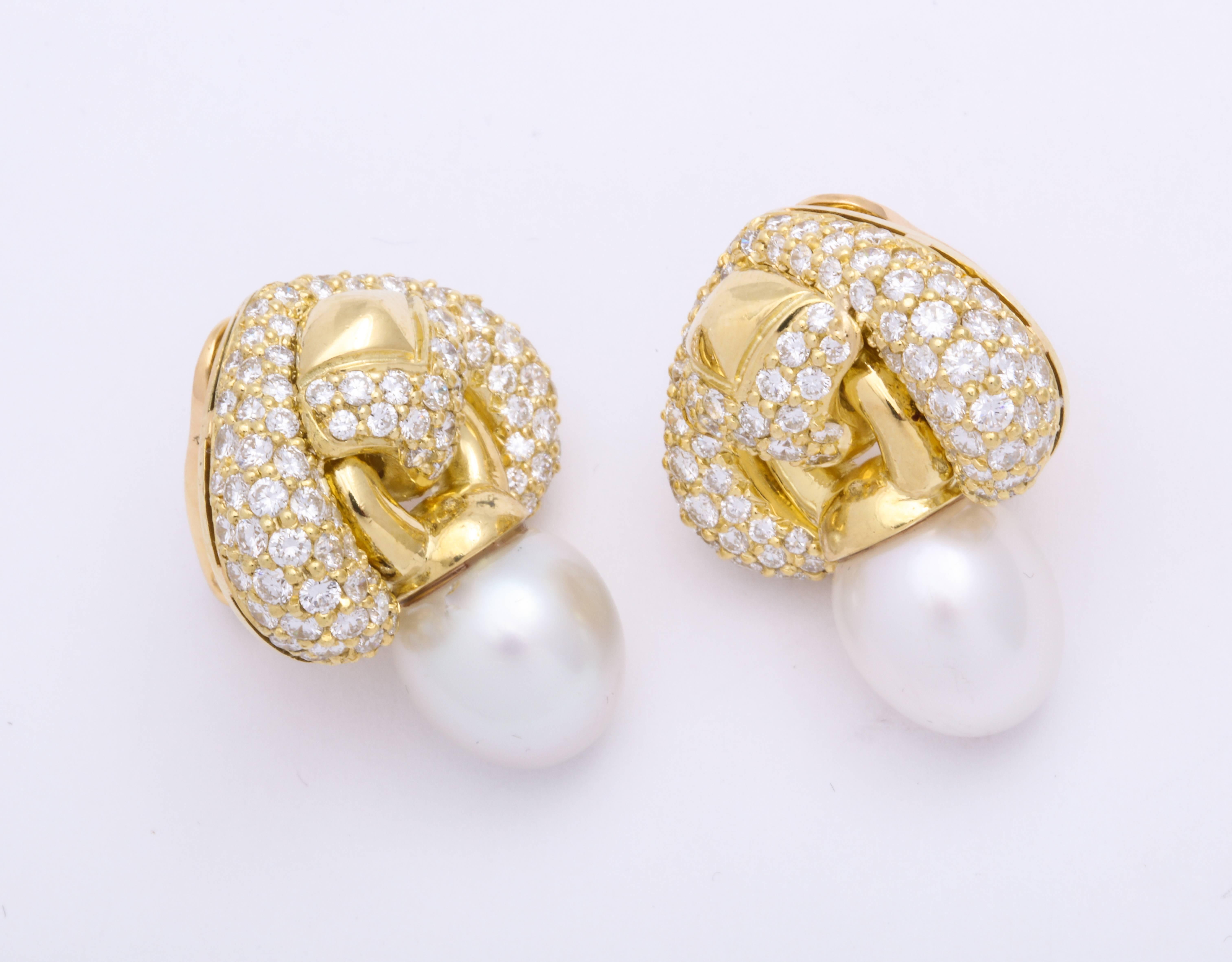 Contemporary and very chic day-into-night 18 Karat yellow gold earrings decorated with round brilliant cut diamonds: 4.84 carats, suspending gently articulating oval shaped silvery-moon color south sea pearls: 12.5 x 11.5 mm. French clip