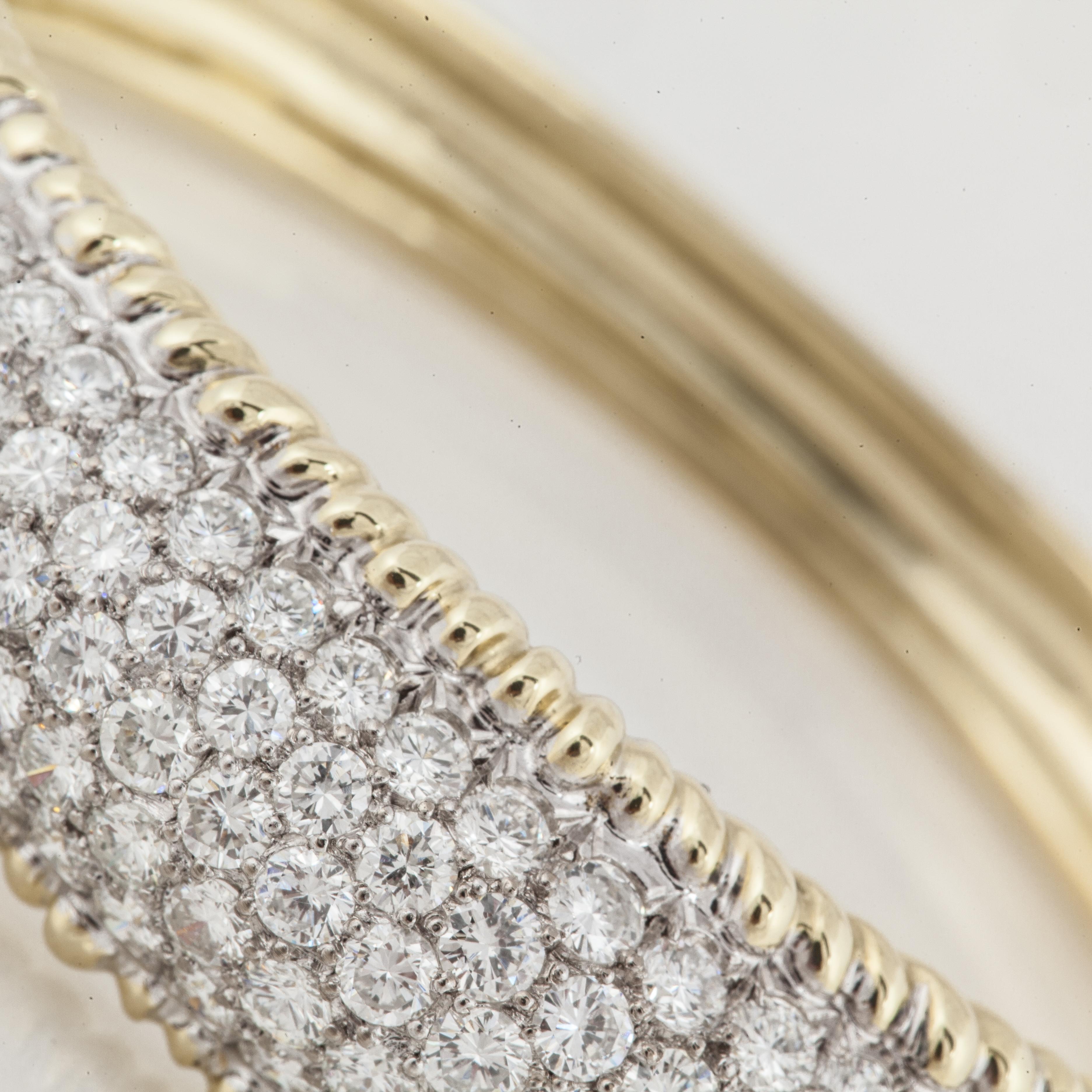 18K yellow gold hinged bangle bracelet with pavé diamonds.  There are a total of 158 round diamonds totaling 10.50 carats; G-H color and VS clarity.  Bangle measures 9/16 inches across the top and the inside diameter measures 2 1/8 inches.  Tongue