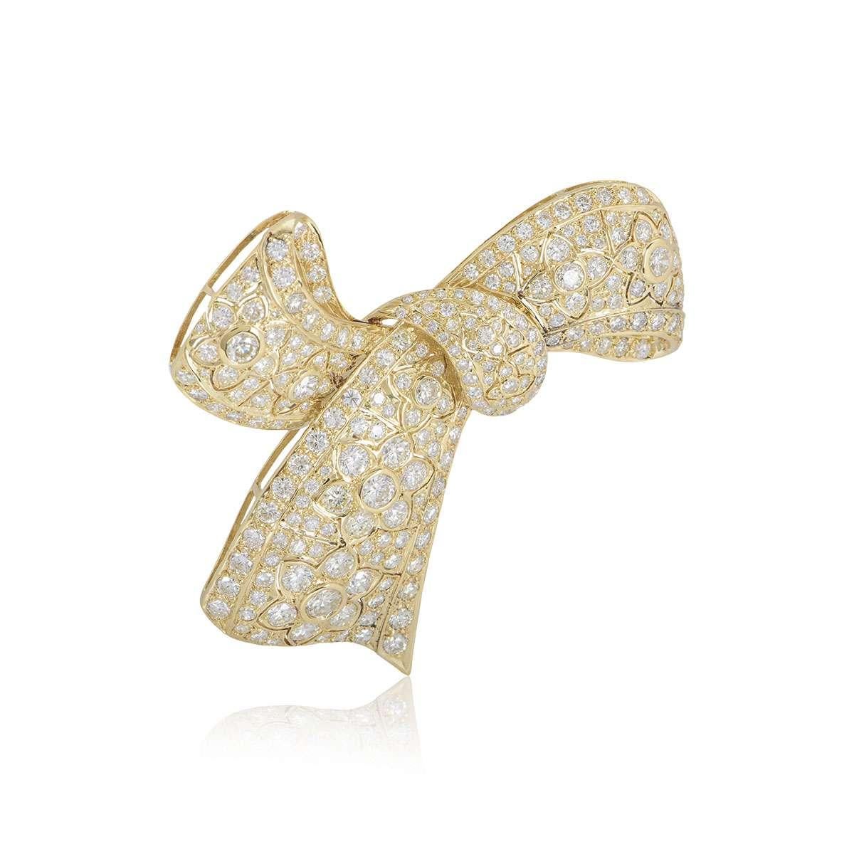 An 18k yellow gold diamond Bow brooch. The brooch is set with round brilliant cut diamonds varying in size, totalling approximately 10.29ct. The brooch measures 6.5cm in width and 7cm in length and has a pin closure to the reverse. The brooch has a