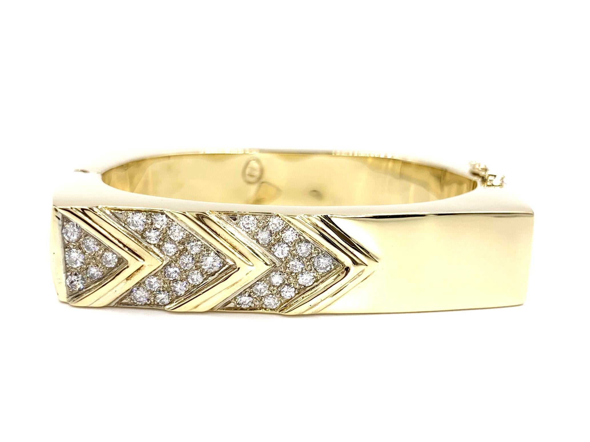 Created in 1978, this modern style polished 14 karat yellow gold square bangle bracelet features 1.62 carats of round diamonds set in a chevron design. Diamonds are approximately G color, SI1-SI2 clarity. Width of bracelet measures 14mm (just over