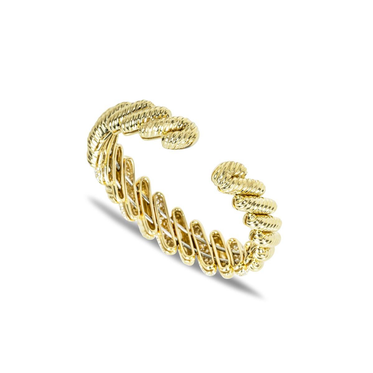 A unique 18k yellow gold diamond cuff bangle. The bracelet features rope pattern links alternating with diamond set links. The diamond links are pave set with 170 round brilliant cut diamonds with an approximate total carat weight of 5.10ct, G-H