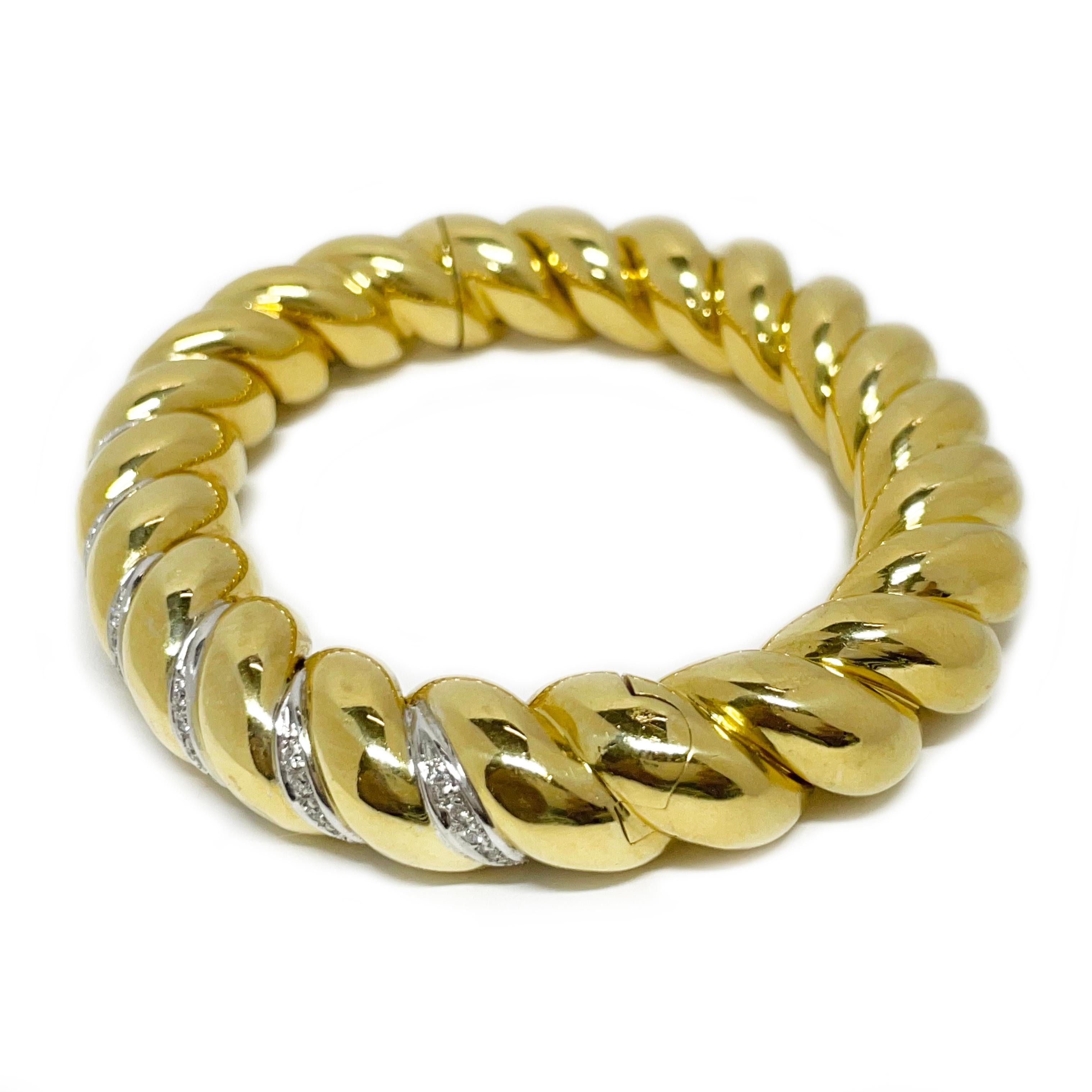 Élevez votre style avec ce superbe bracelet San MarCo en or jaune 18 carats, qui présente un élégant motif de corde torsadée rehaussé de diamants brillants. Fabriquée en or 18 carats luxueux, cette manchette a une largeur audacieuse de 13 mm et un