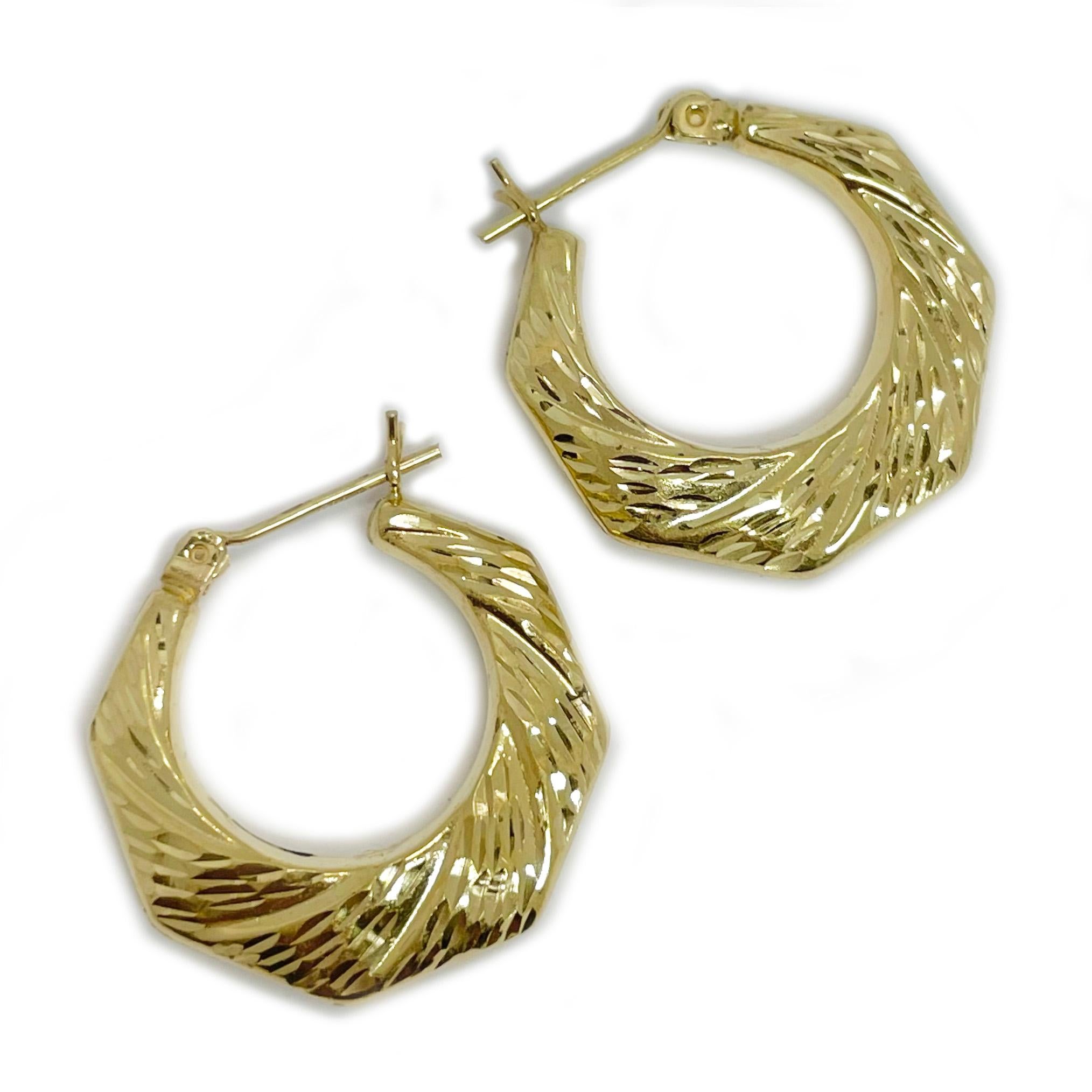 14 Karat Yellow Gold Diamond Cut Hoop Earrings. The earrings are lightweight and could be worn daily or with a dressier outfit. The outside shape is has straight lines while the inside shape is circular with diamond cut details on both side. The