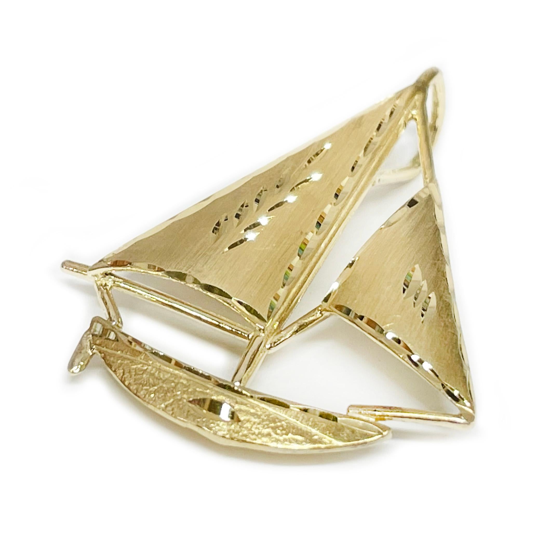 Yellow Gold Diamond-Cut Sail Boat Pendant. The pendant has an overall brush finish with diamond cut details along the sails and the top portion of the boat. The pendant has a wide attached bail to accommodate either a thin or thick chain. The