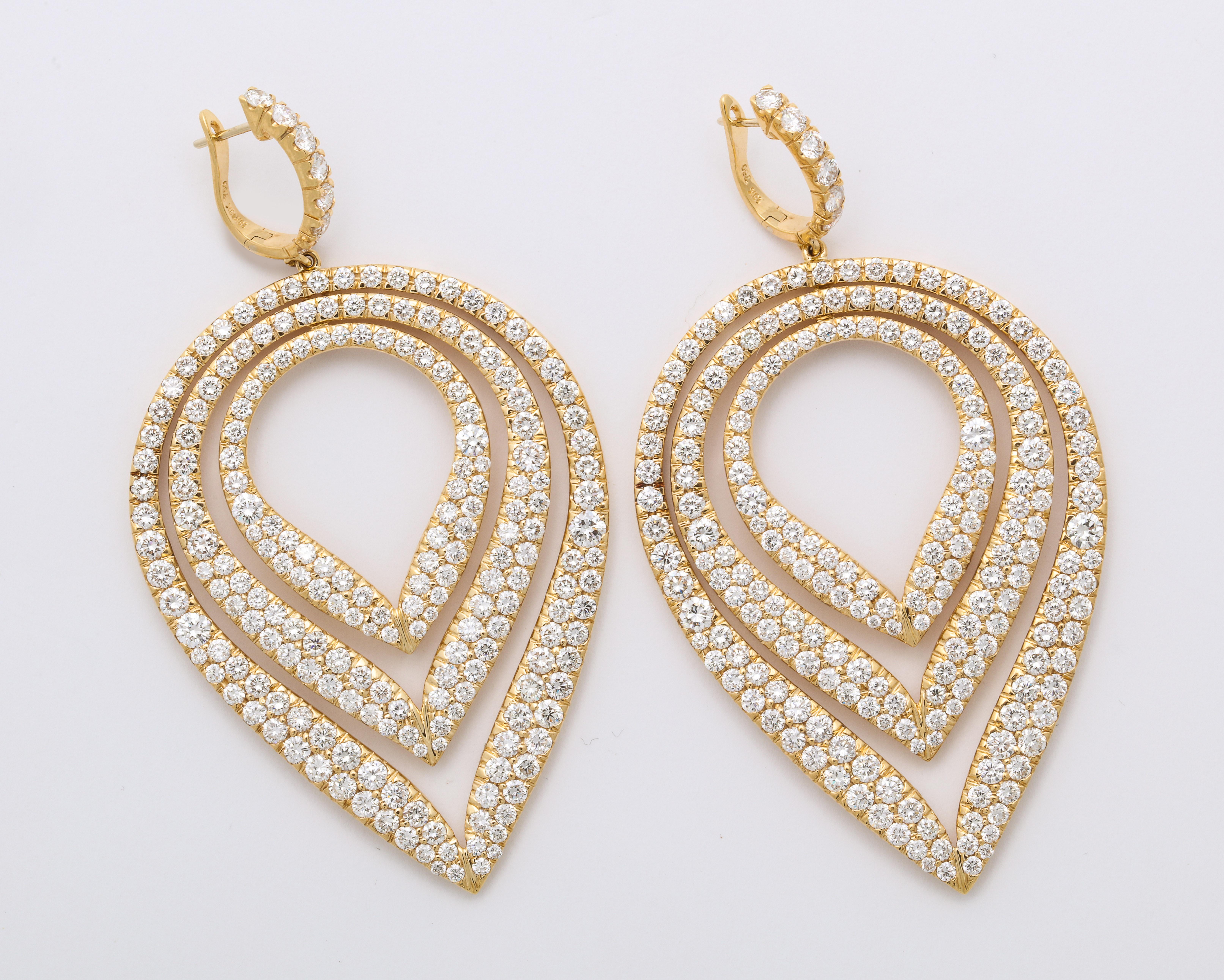 Dazzling 18K yellow gold semi-hoop earrings suspending articulating inverted concentric pear-shape pendants decorated entirely with colorless pave'-set round brilliant-cut diamonds: 14.78 carats.
Earrings are fitted with posts for pierced ears