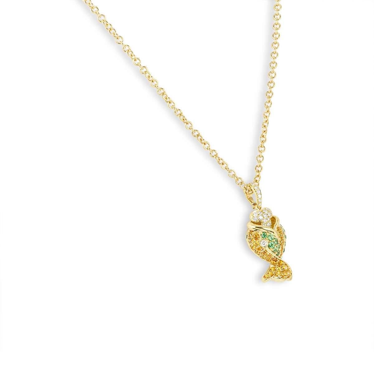 An 18k yellow gold fish pendant. The fish motif is set with round brilliant cut diamonds, emeralds and yellow sapphires. The diamonds total approximately 0.44ct, the sapphires total 0.72ct and the yellow sapphires total 1.12ct. The pendant measures
