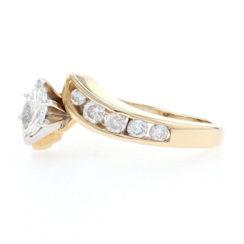 Composed of 14k yellow and gold, this radiantly beautiful engagement ring will be an exceptional choice for your one true love! This piece showcases a marquise cut diamond held in a raised, six-prong mount that is gracefully accompanied by ten