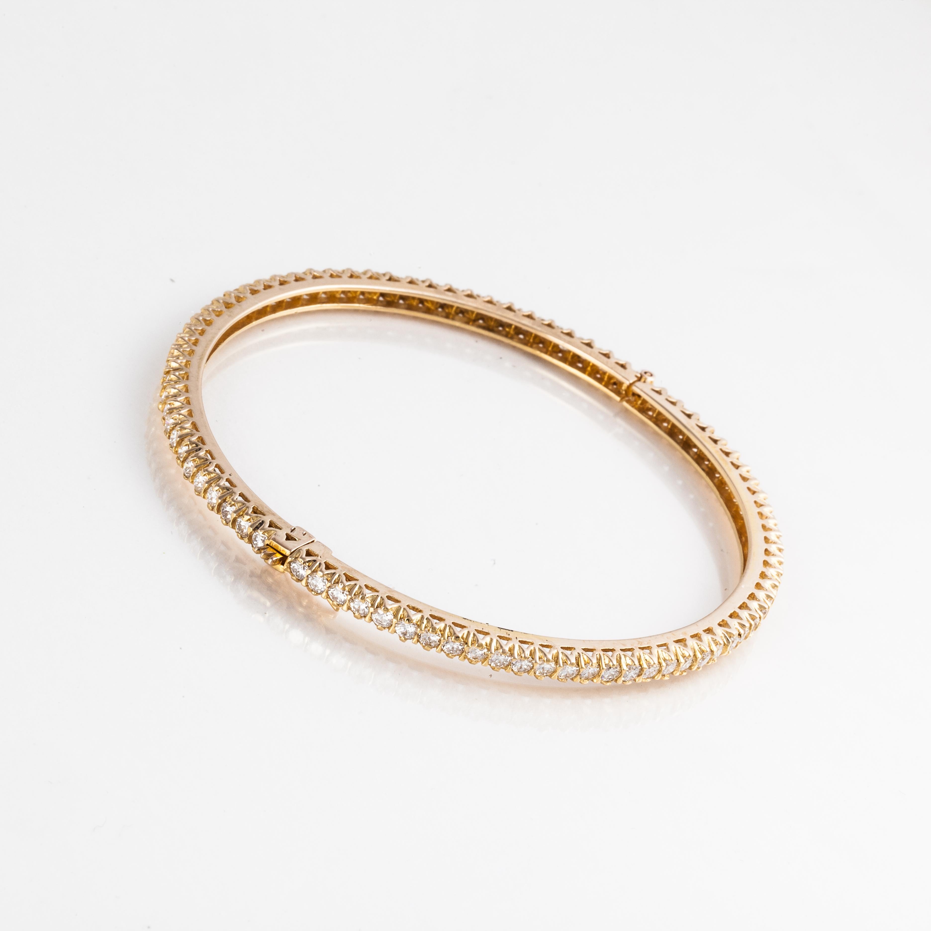 18K yellow gold bangle bracelet with round diamonds all the way around.  There are a total of 84 round diamonds that total 5 carats; G-H color and VS-SI clarity.  Bracelet measures 1/8 inches wide and the inside diameter is 2 1/4 inches.  Hinged
