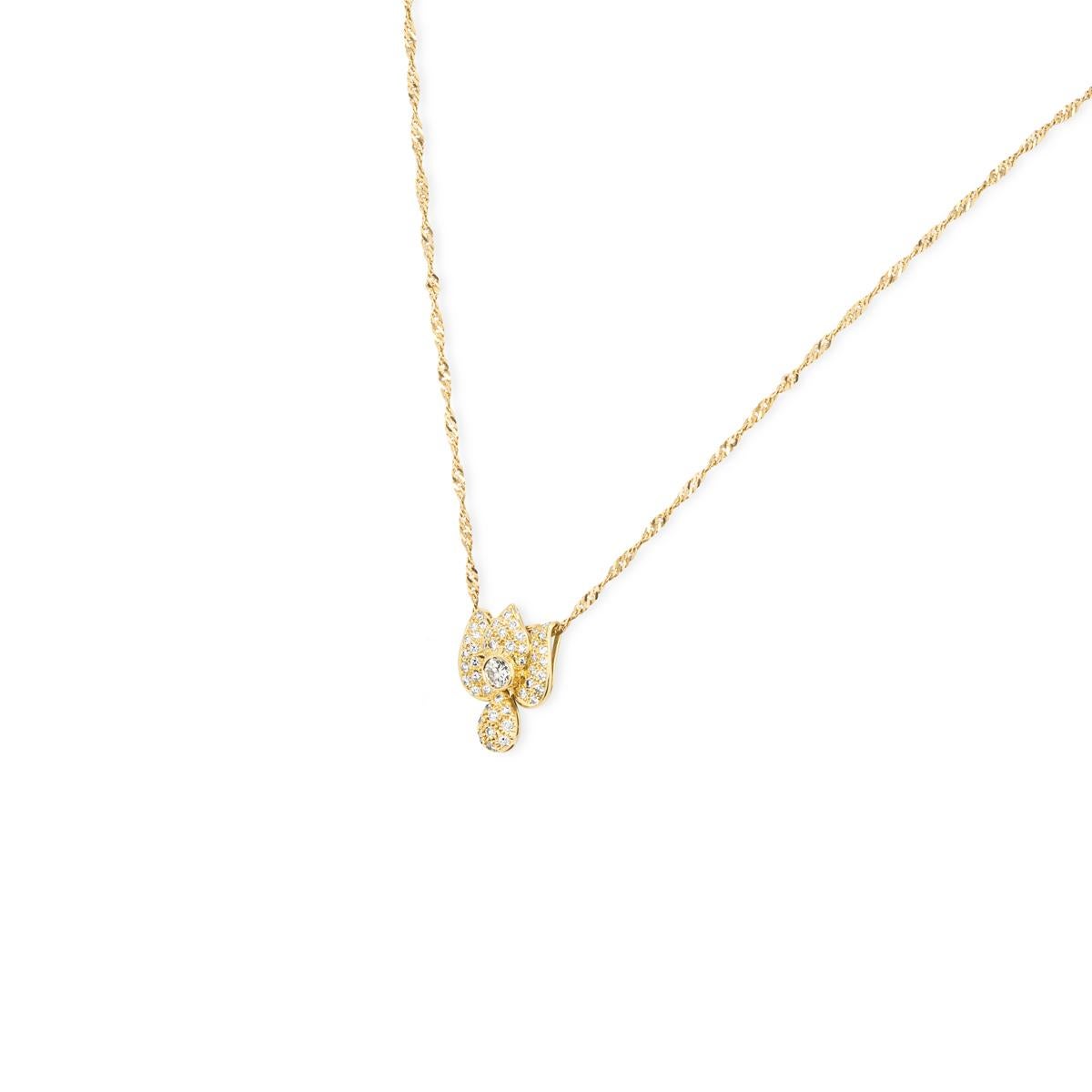 A radiant 18k yellow gold diamond floral pendant. The pendant features a floral design with a freely moving tear drop motif suspended underneath. Set to the centre of the pendant is a round brilliant cut diamond in a rubover setting weighing