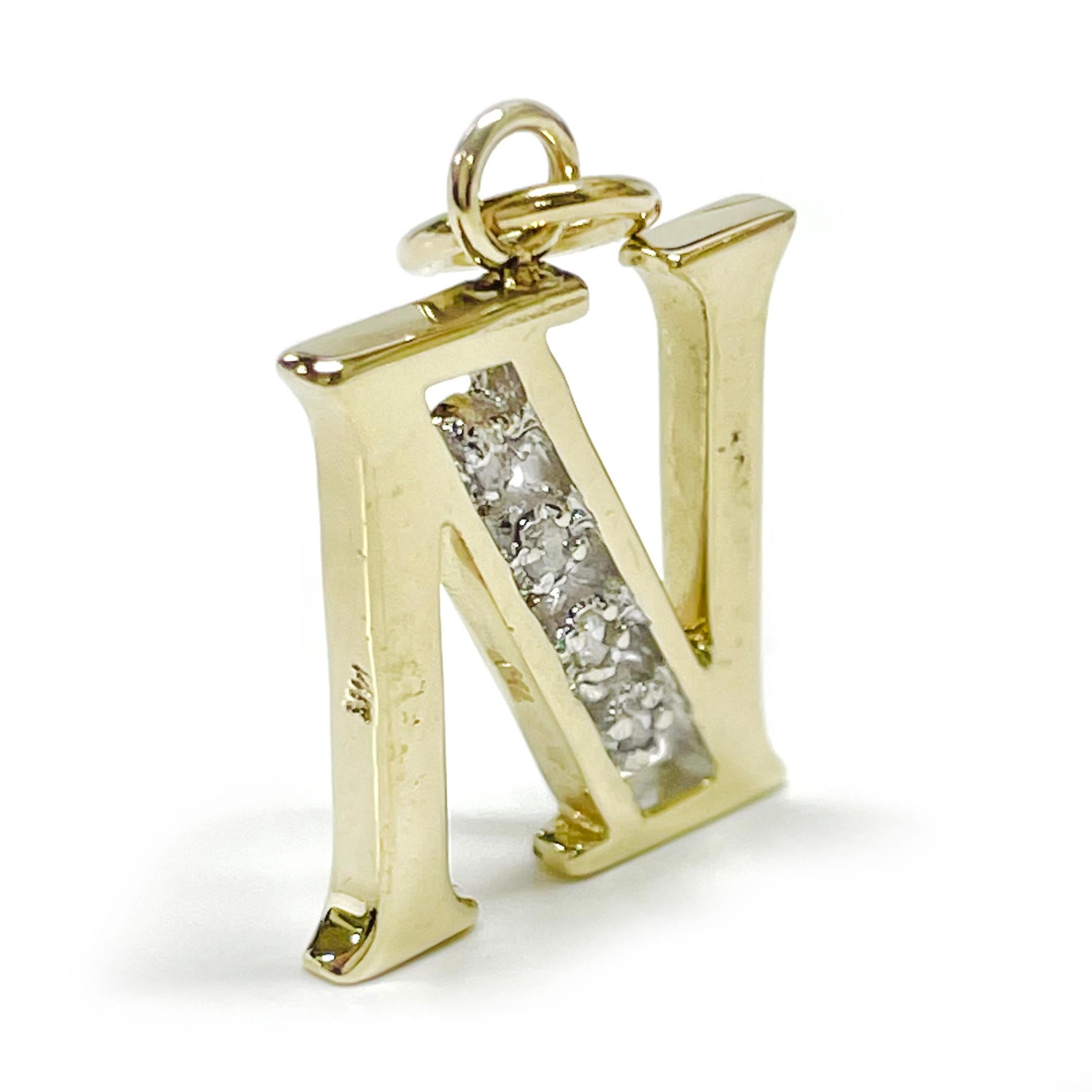 14 Karat Yellow Gold Diamond Initial N Pendant. The capital letter is open in the middle with four round diamonds set to resemble channel setting. The four single-cut diamonds are 1.56mm with a total carat weight of 0.03ctw. The diamonds are I1-I2