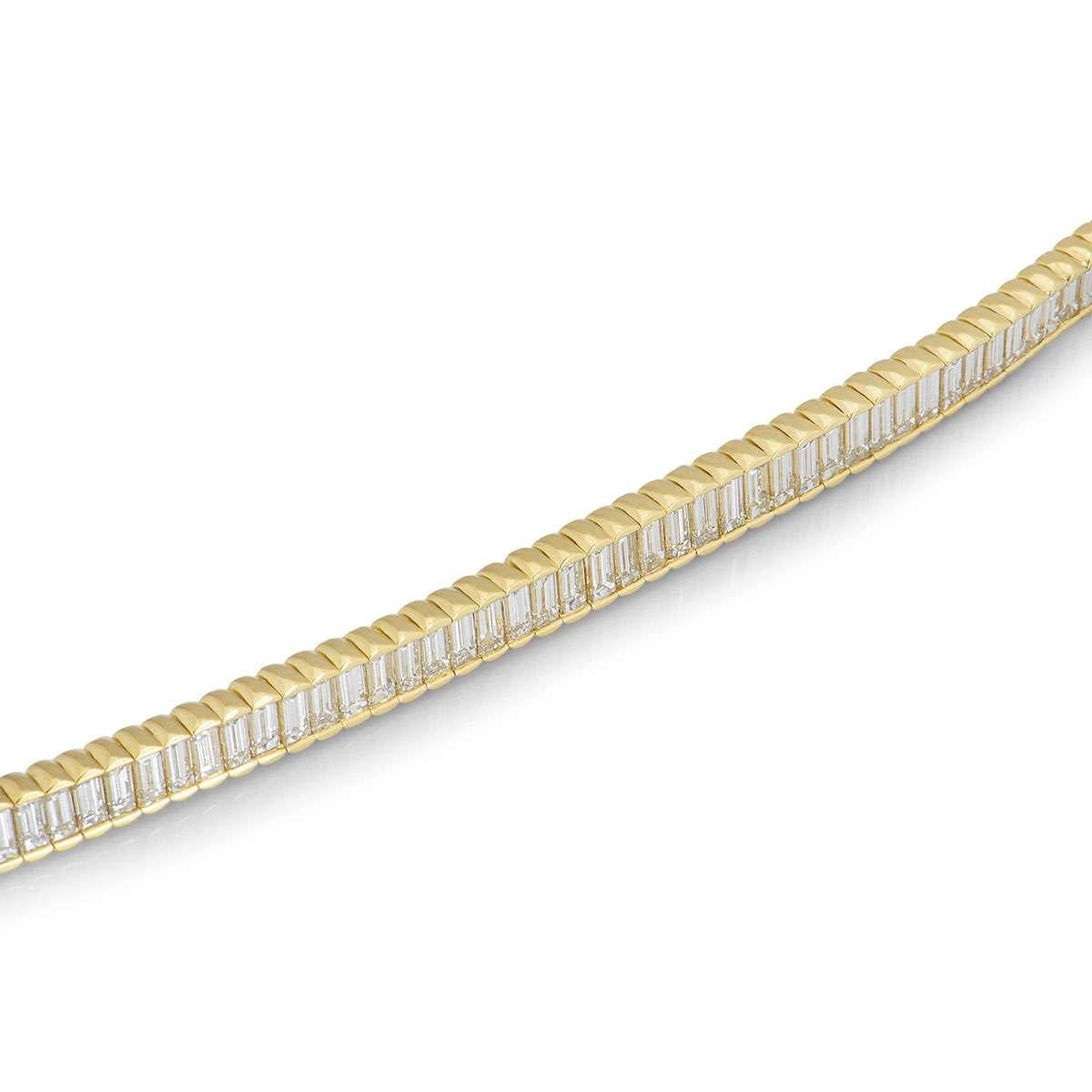 A beautiful 18k yellow gold diamond line bracelet. The bracelet features 72 baguette cut diamonds set within a yellow gold tension setting with a total weight of approximately 11.52ct. The bracelet measures 7 inches in length and is complete with a