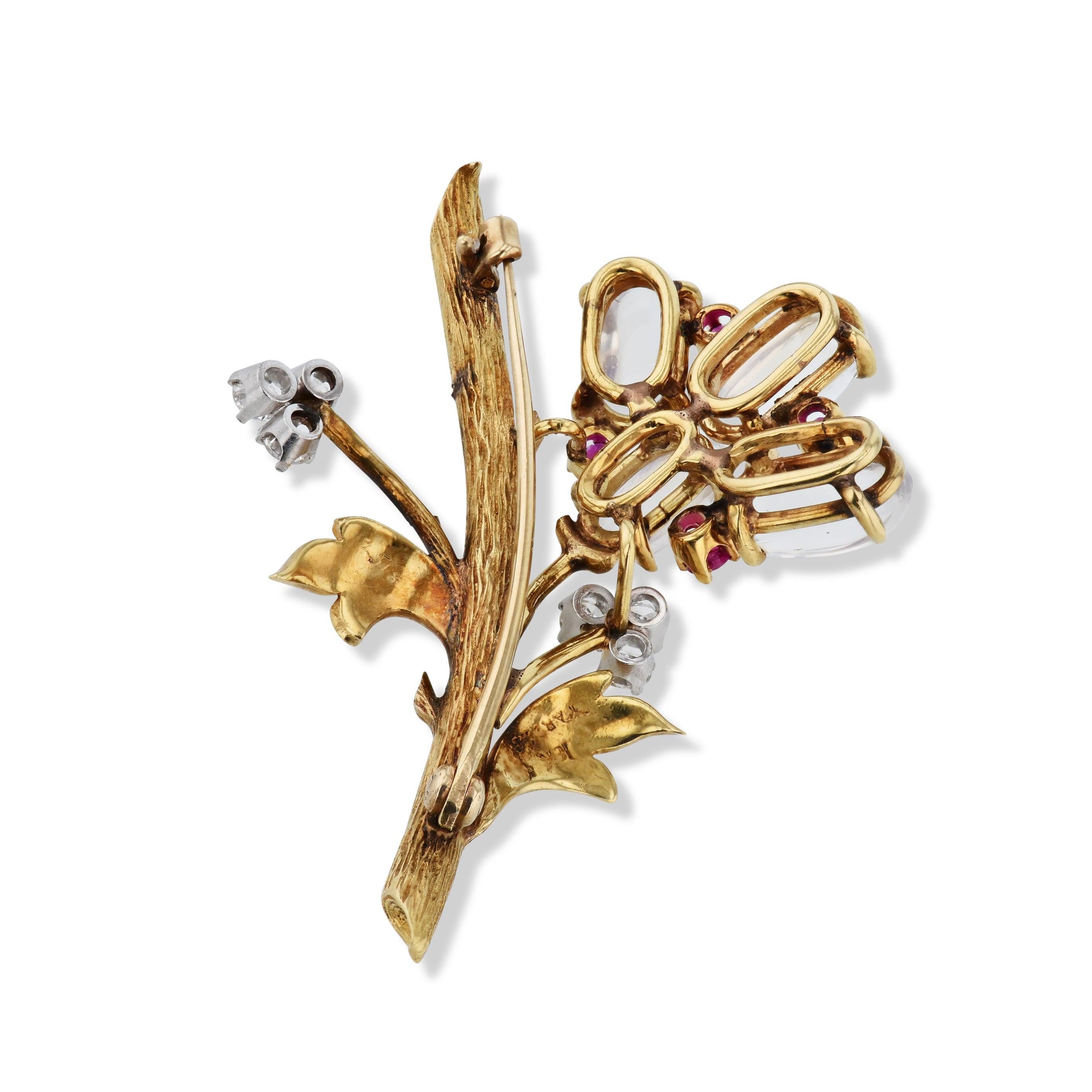 Crafted from 18kt. yellow gold, this exquisite estate brooch showcases six dazzling diamonds, four shimmering moonstones, and four vibrant rubies! A large pin on the back ensures you'll be able to secure it with ease. Signed 