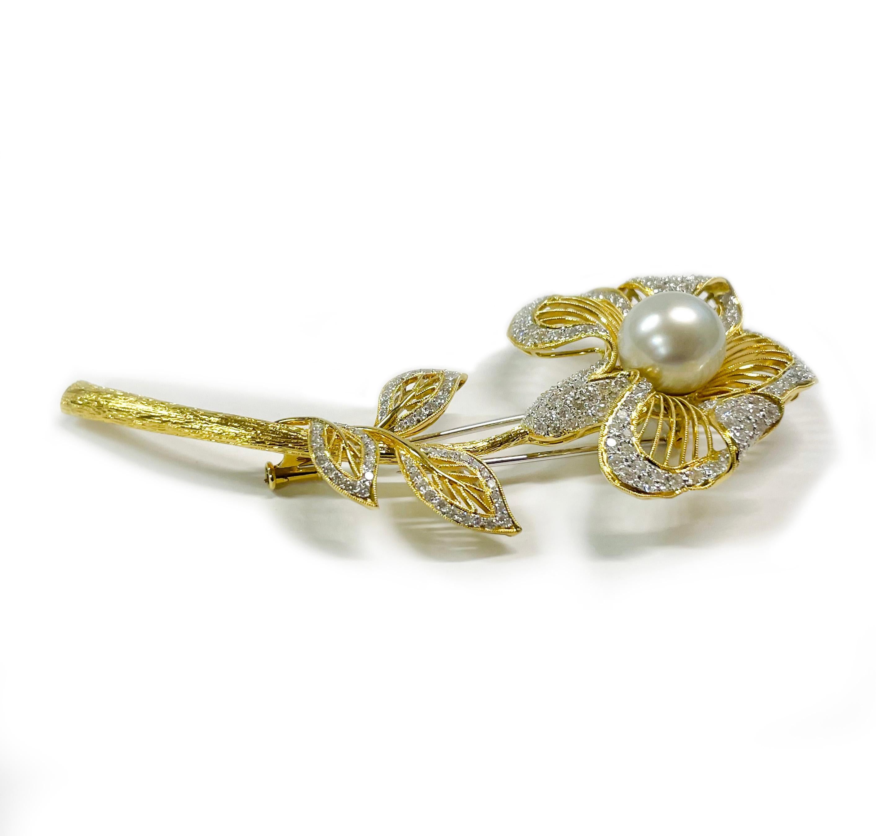 Broche fleur en or jaune et blanc 18 carats avec diamants et perles. La broche comporte une perle des mers du Sud de 11,5 mm et 171 diamants ronds de taille brillant. La perle a un bon lustre avec des nuances de rose et de bleu. Les diamants ornent