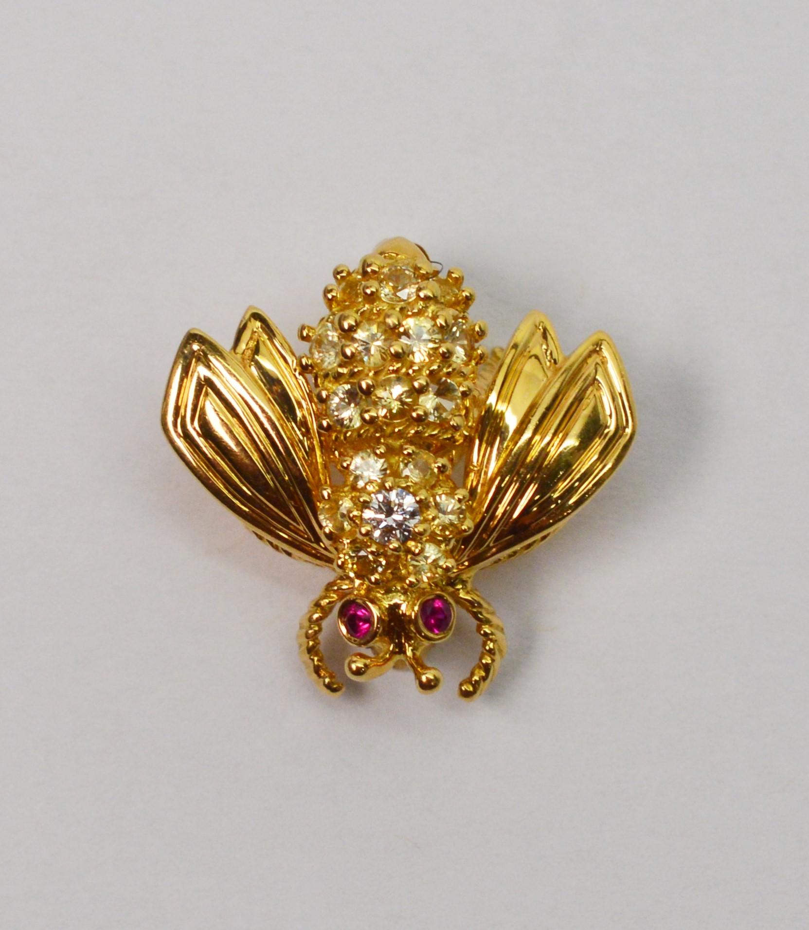 Adorable eighteen karat 18K yellow gold Tiffany & Company Bumble Bee Pin Brooch with diamond back and ruby eyes. Approximately -.75 carats.
Mint condition. Measures Approximately 3/4 inch long and about the same wing to wing.