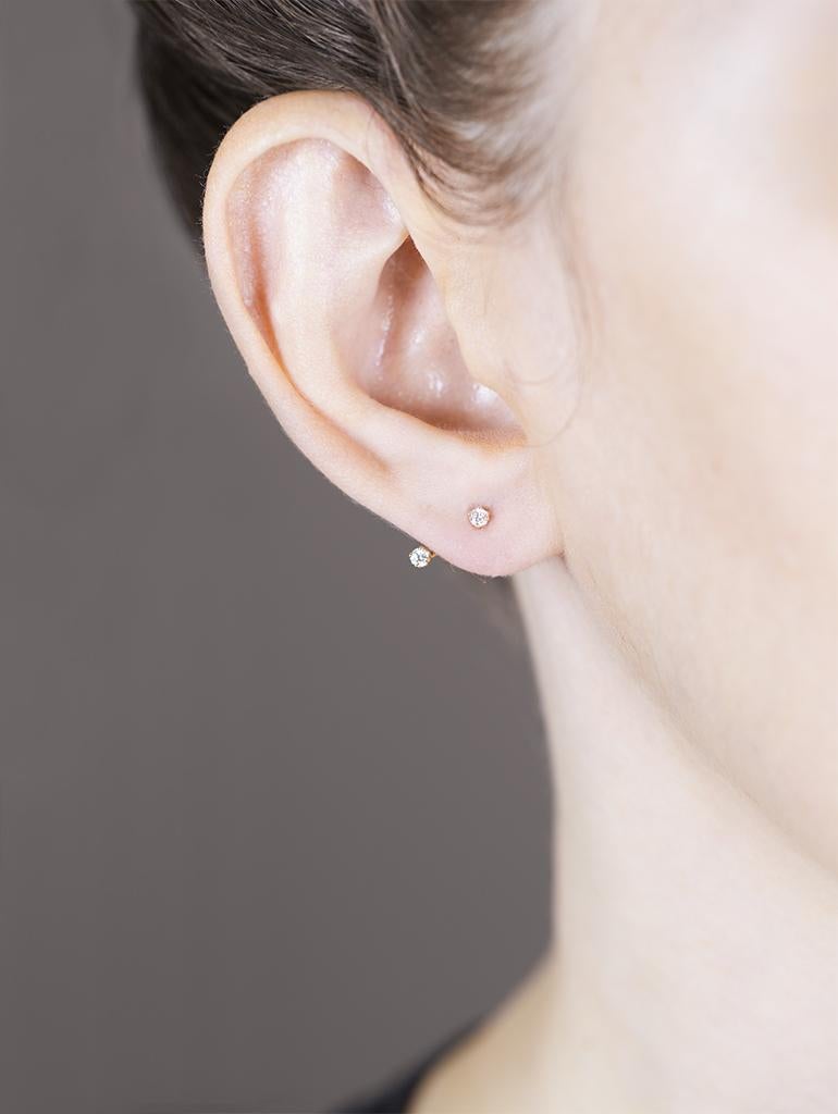 Sparkling white diamonds float on the ear, 1 on the post, and 1 from the jacket backing of these versatile modern earrings. Backings have 2 holes for an adjustable fit and can be worn multiple ways (with the diamond included or any of your favorite