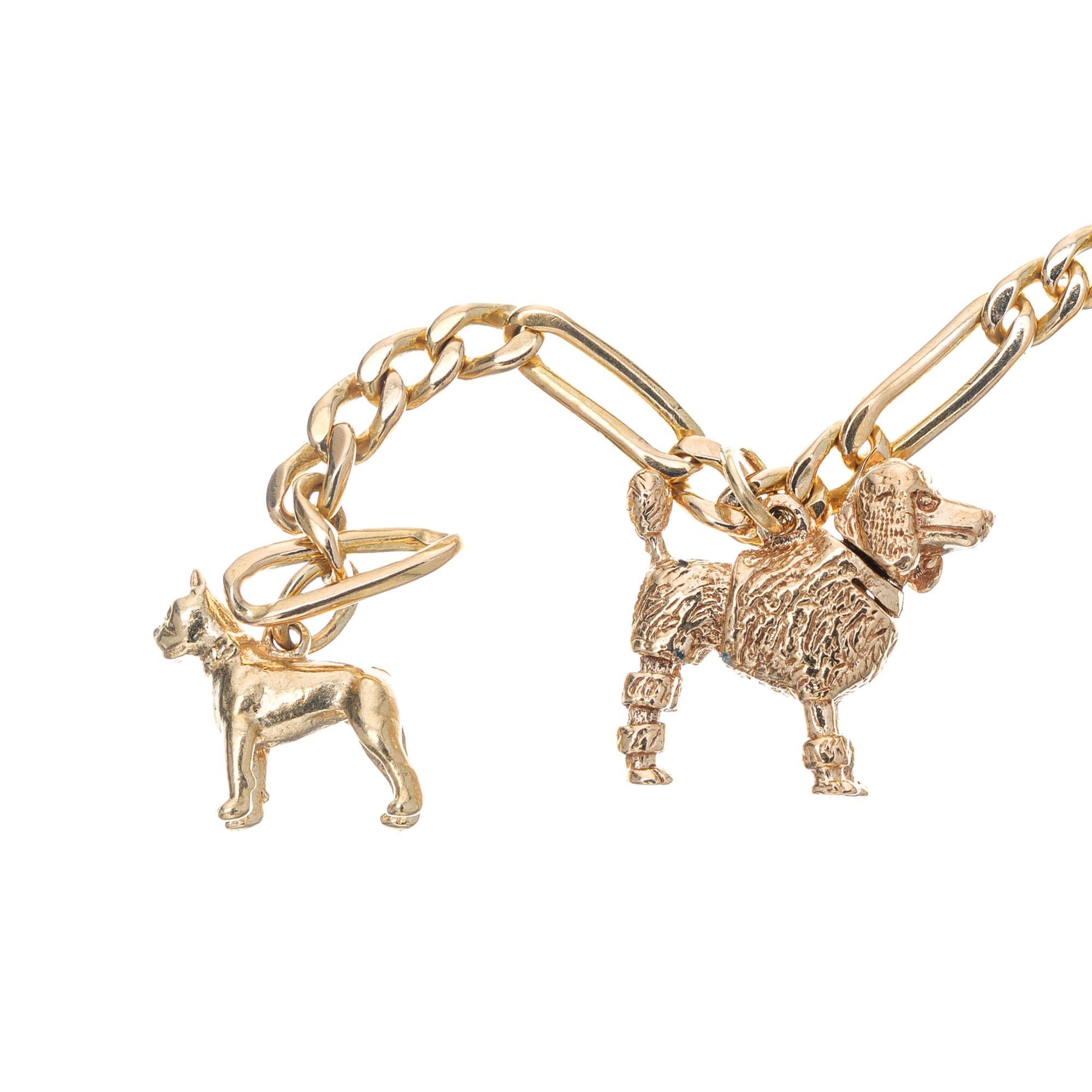 Link charm bracelet with five dog charms. The center charm is 2D, the others are 3D. The poodle and scottie have movable heads. 7.25 inches in length. 

14k yellow gold 
Stamped: 14k
21.0 grams
Chain: 7.25 Inches
