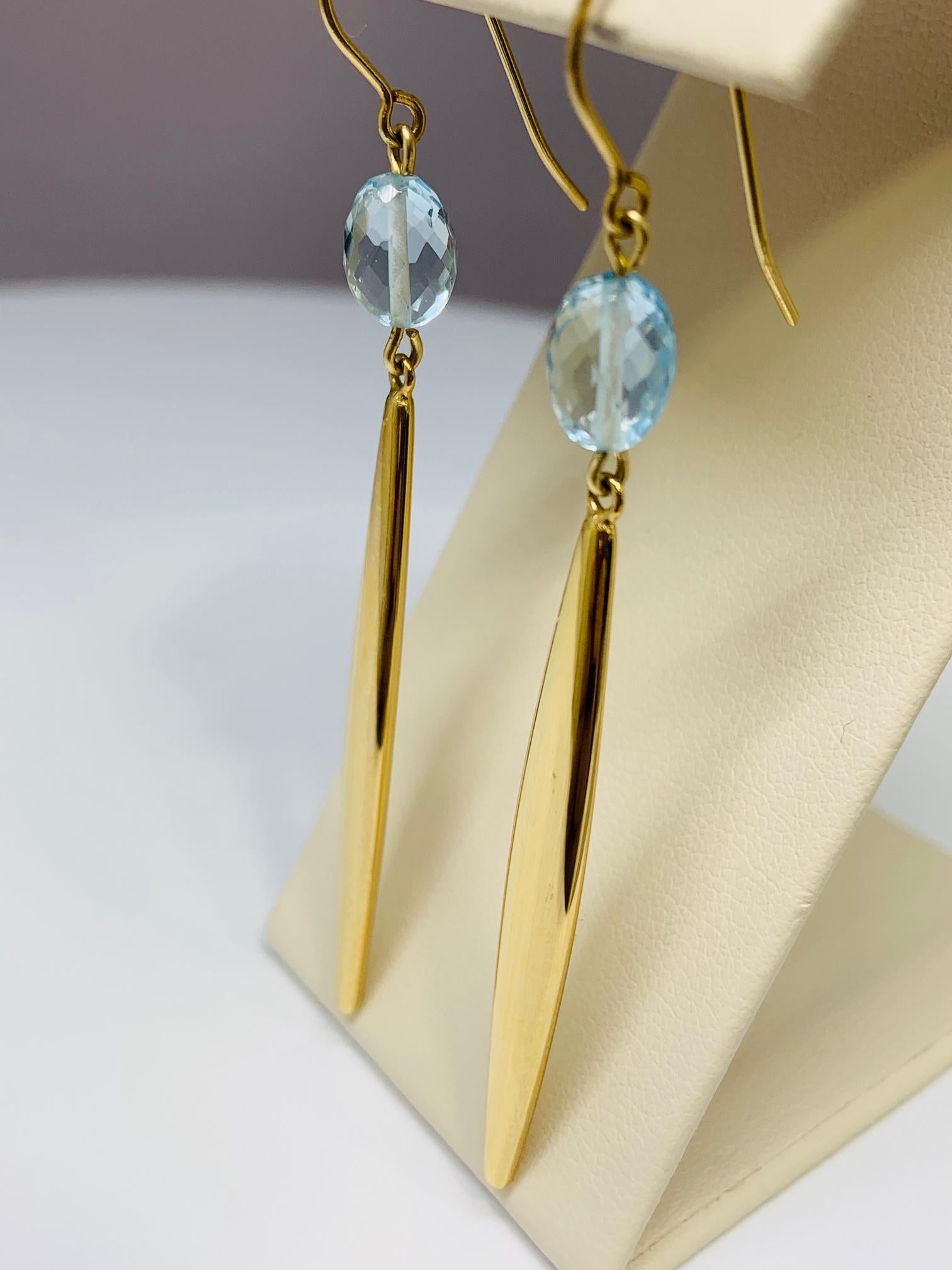 These beautiful drop earrings are made of 14K yellow gold and include two 8 x 5 millimeter elongated oval blue topaz stones! The blue topaz are faceted for extra sparkle and dimension. These earrings drop approximately 2.5 inches down from the