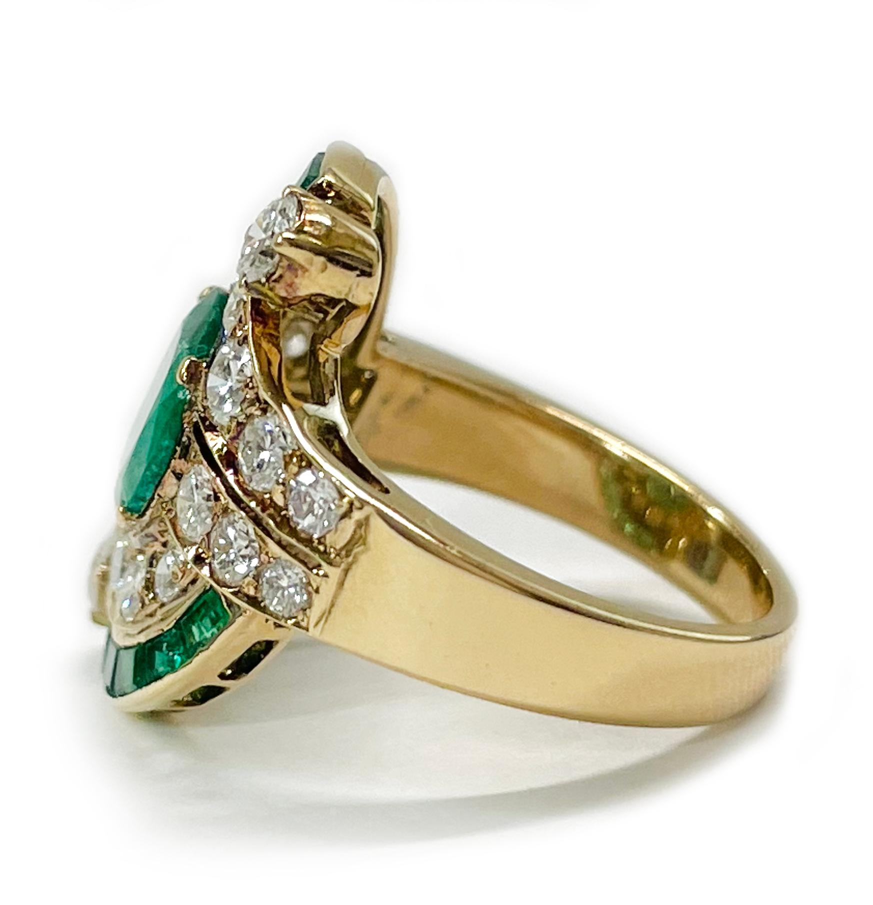 Yellow Gold Emerald Diamond Ring. The lovely ring features a center oval emerald with round diamonds surrounding the emerald two arches of channel set princess cut emeralds and a round diamonds at the end. The center emerald measures 9 x 7mm and has