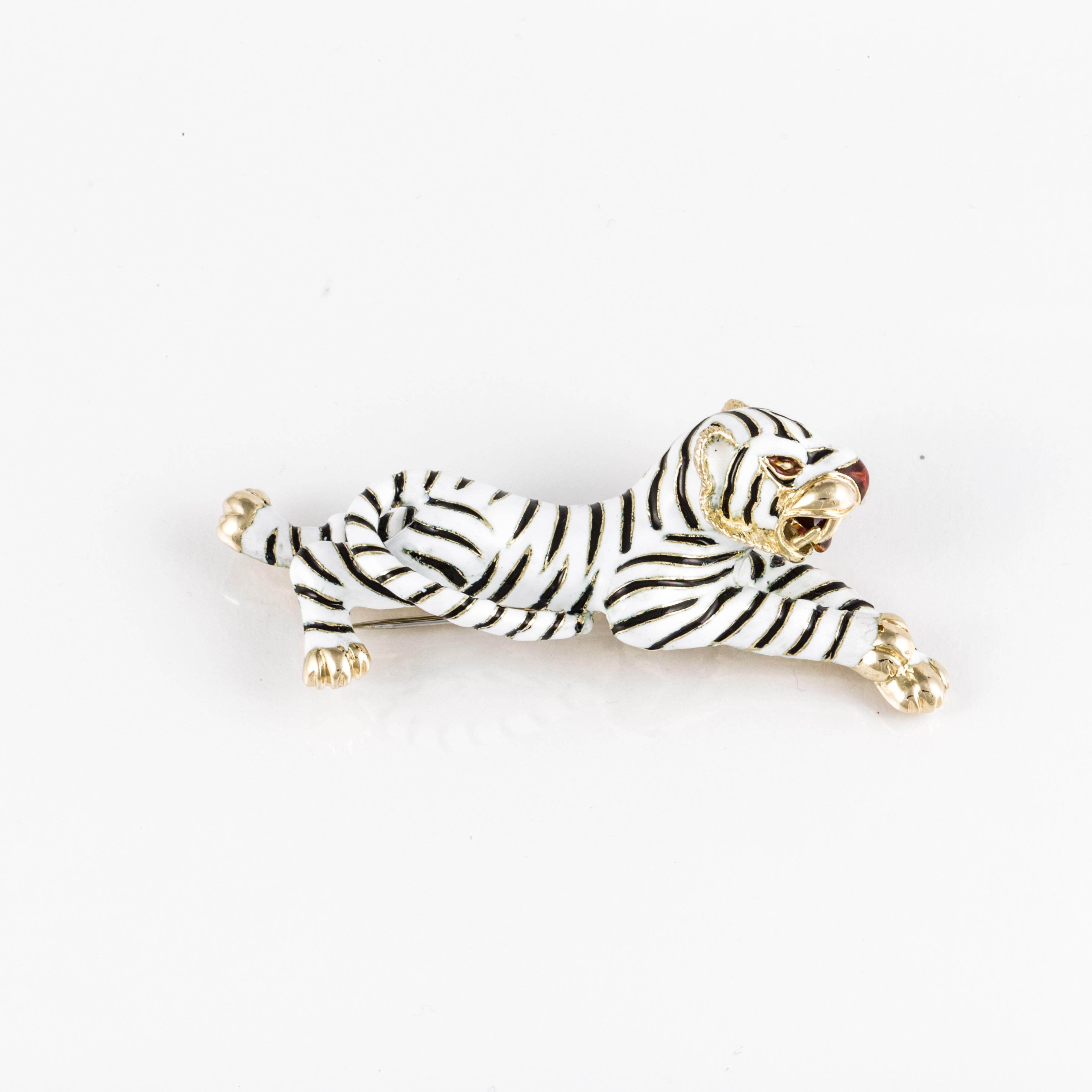 Tiger brooch composed of 18K yellow gold with white enamel body and black enamel stripes.  Both the tongue and nose are red enamel.  The outstretched tiger measures 3 inches long, 3/4 inches wide and stands 1 inch tall.  Closure is a double prong