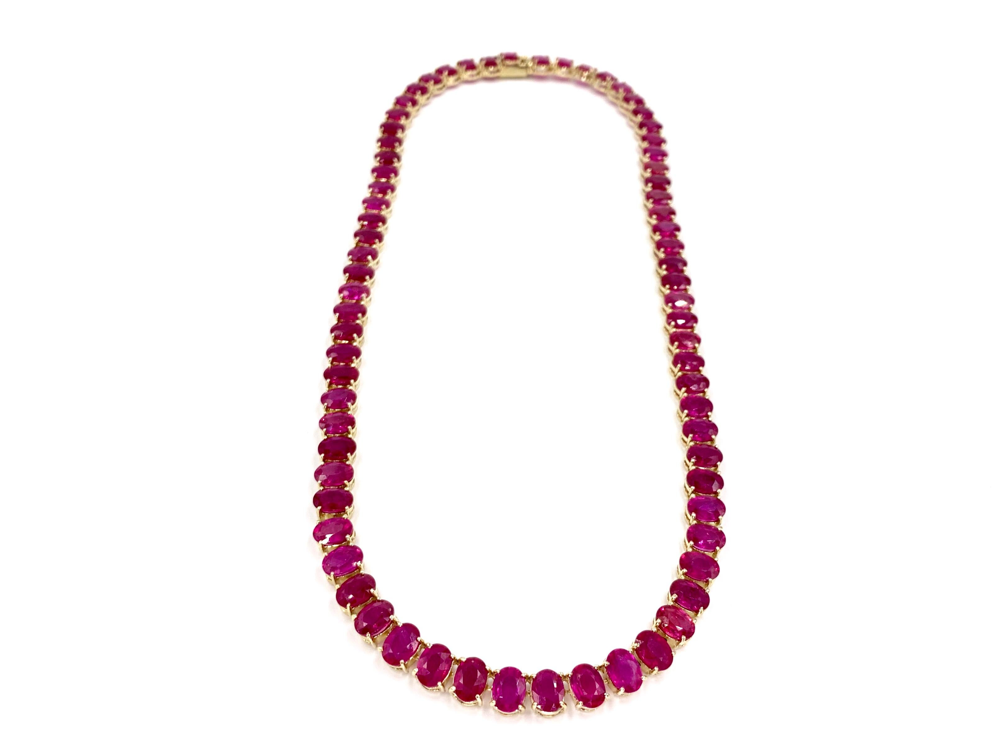 Circa 1970's, a gorgeous endless style vivid ruby 14 karat yellow gold necklace. Necklace is composed of 72 oval rubies at approximately .90 carats each. Total ruby weight of necklace is approximately 64.80 carats. Pinkish-red rubies have excellent