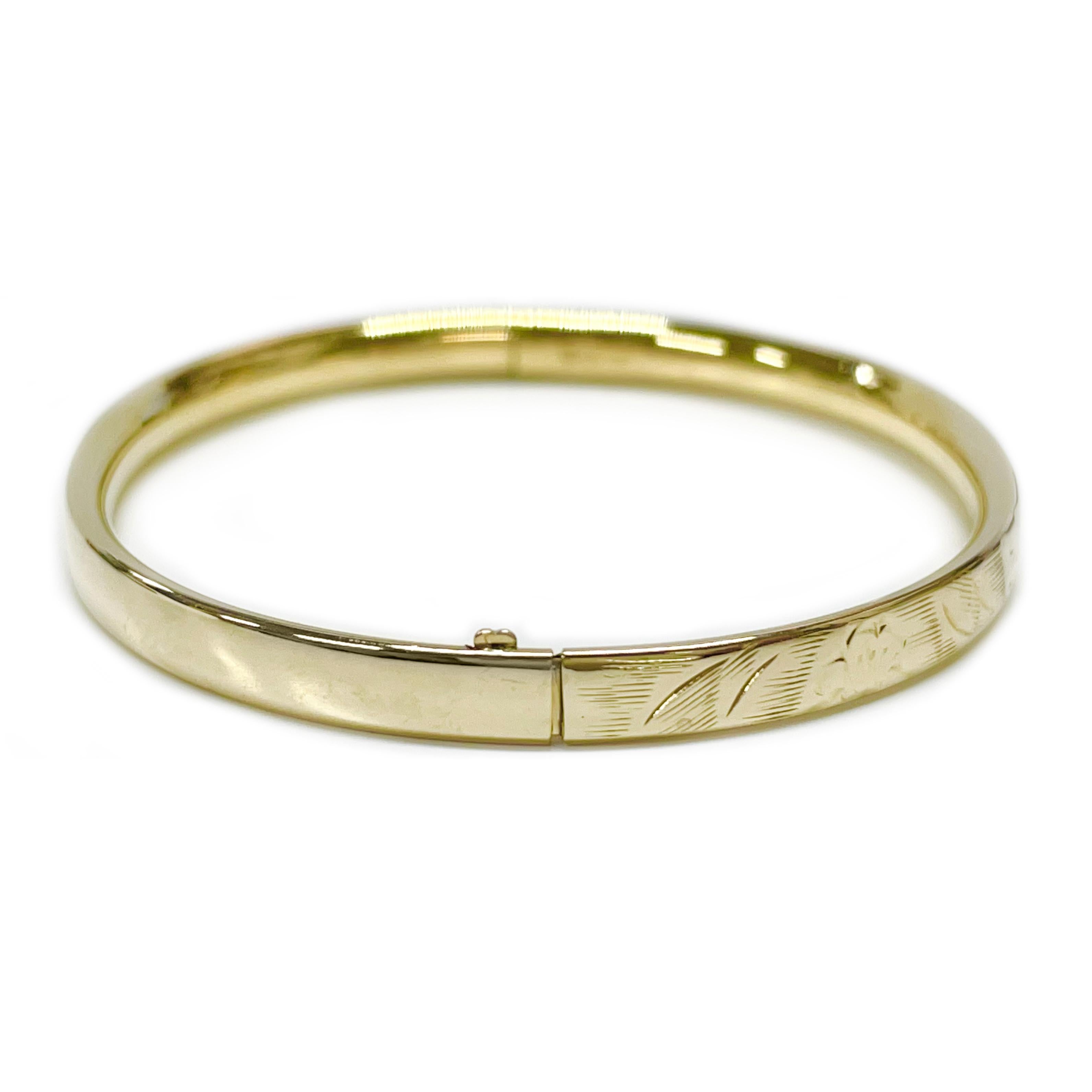 14 Karat Yellow Gold Engraved Baby Bangle Bracelet. The bracelet has an overall smooth shiny finish with engraved floral accents. When the hinged bangle bracelet is stamped 14K BAB on the inside of the bangle. The bracelet is 3.8mm wide. The